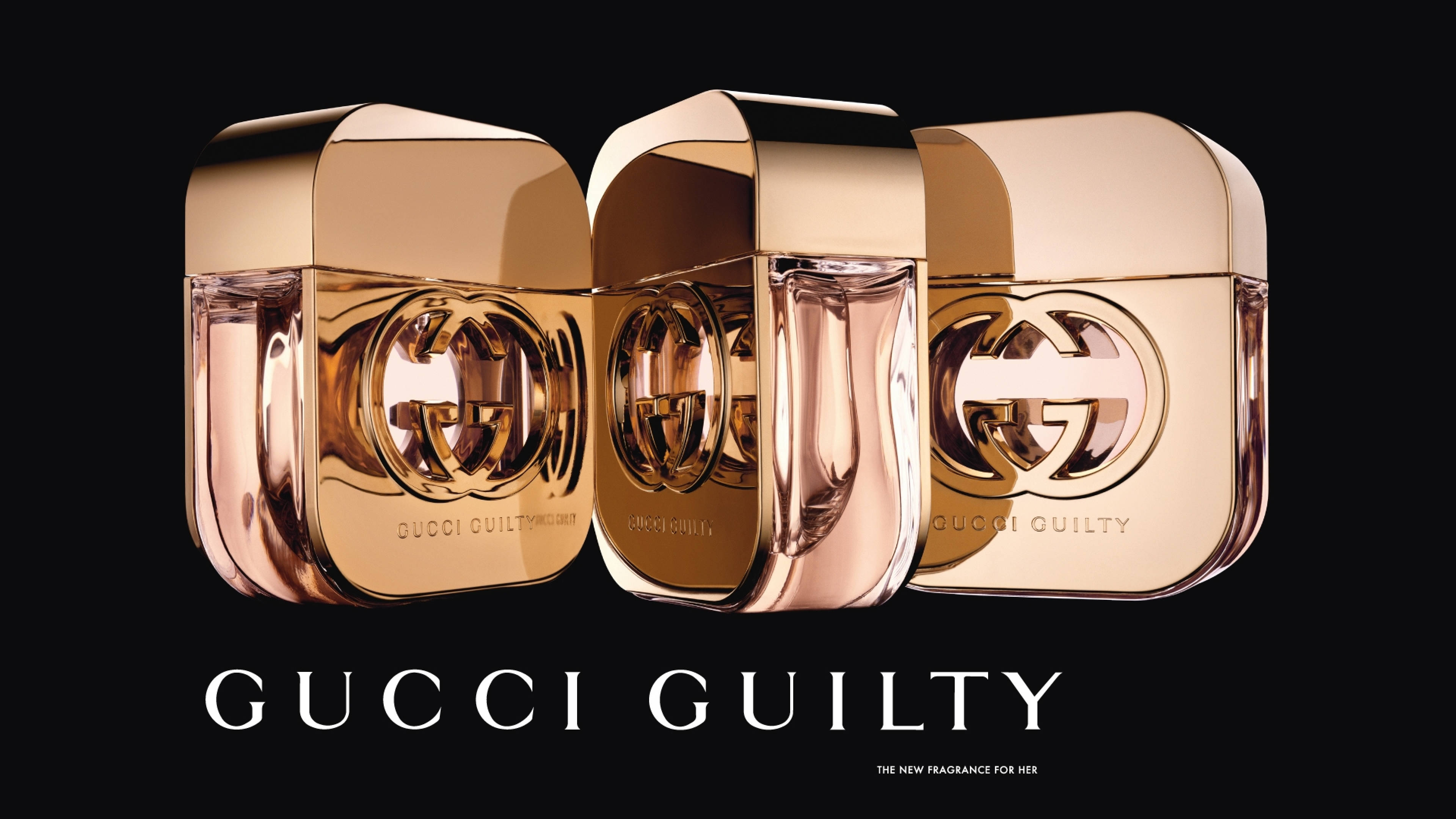三支Gucci Guilty香水瓶，帶玫瑰金瓶蓋和黑色背景。 — Gucci GIF 壁紙