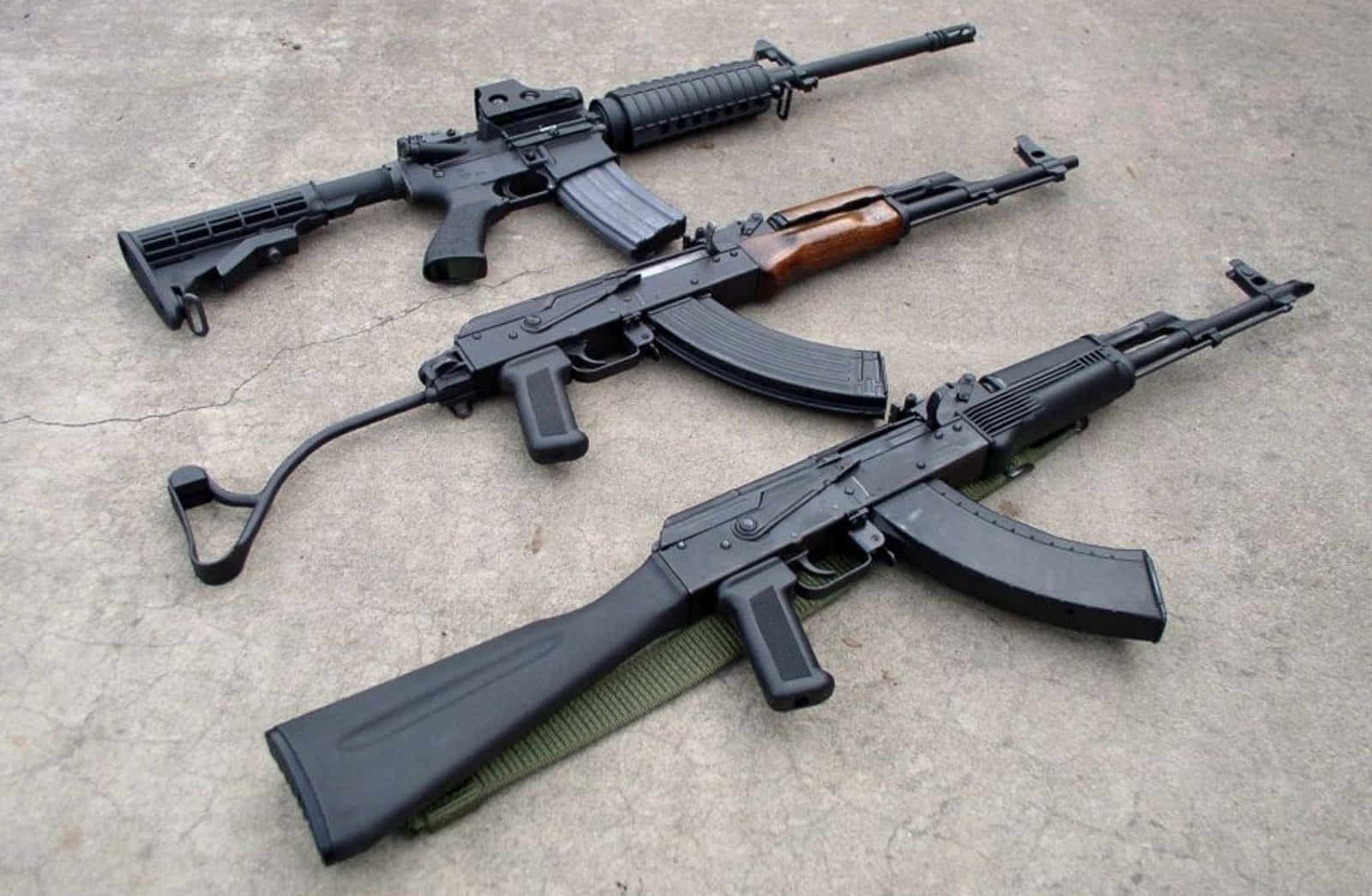 Rifle 桌布 壁紙 — 三支軍用步槍以簡樸實用的方式放置在裂開的混凝土地面上。