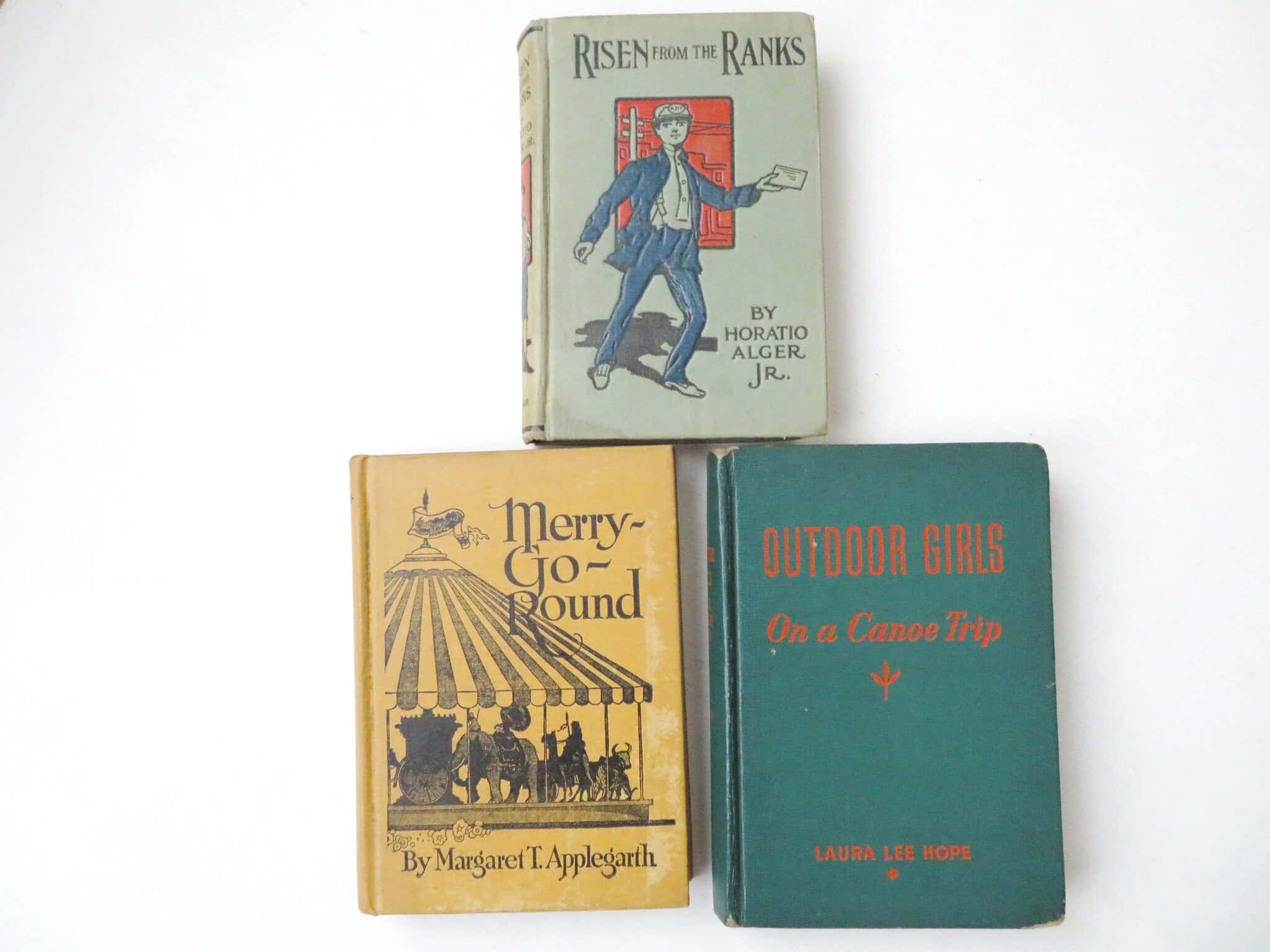 books 桌布 壁紙 — 三本帶插圖封面的復古兒童讀物，排列在純白色表面上。