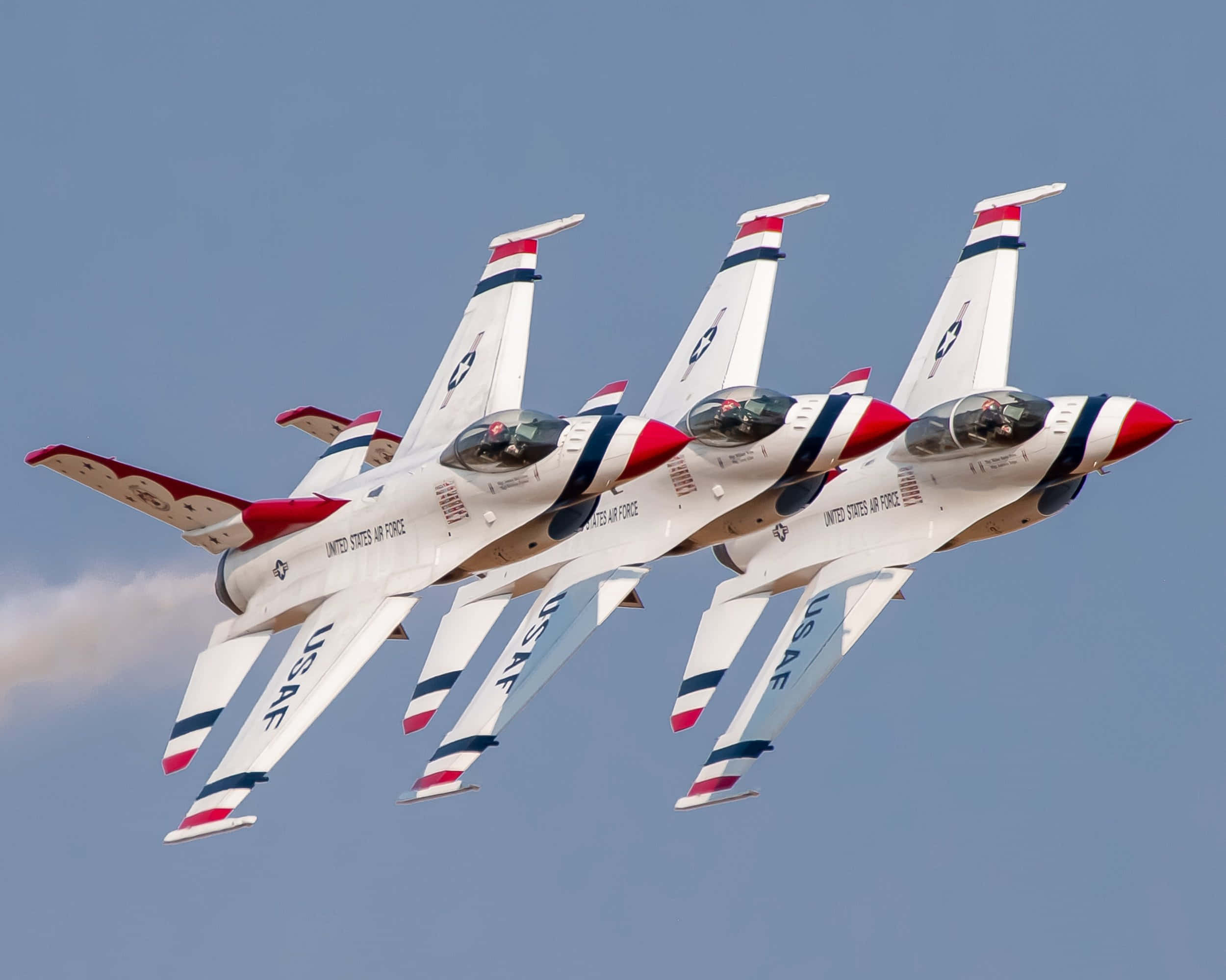Air Force 桌布 壁紙 — 三架美國空軍雷鳥戰鬥機在晴朗的藍天下緊密編隊飛行，留下一道白色煙霧痕跡。