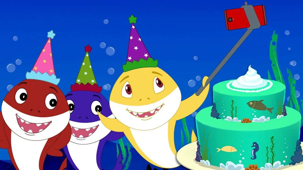 baby shark 桌布 壁紙 — 三條卡通鯊魚戴著派對帽在水底與蛋糕自拍。