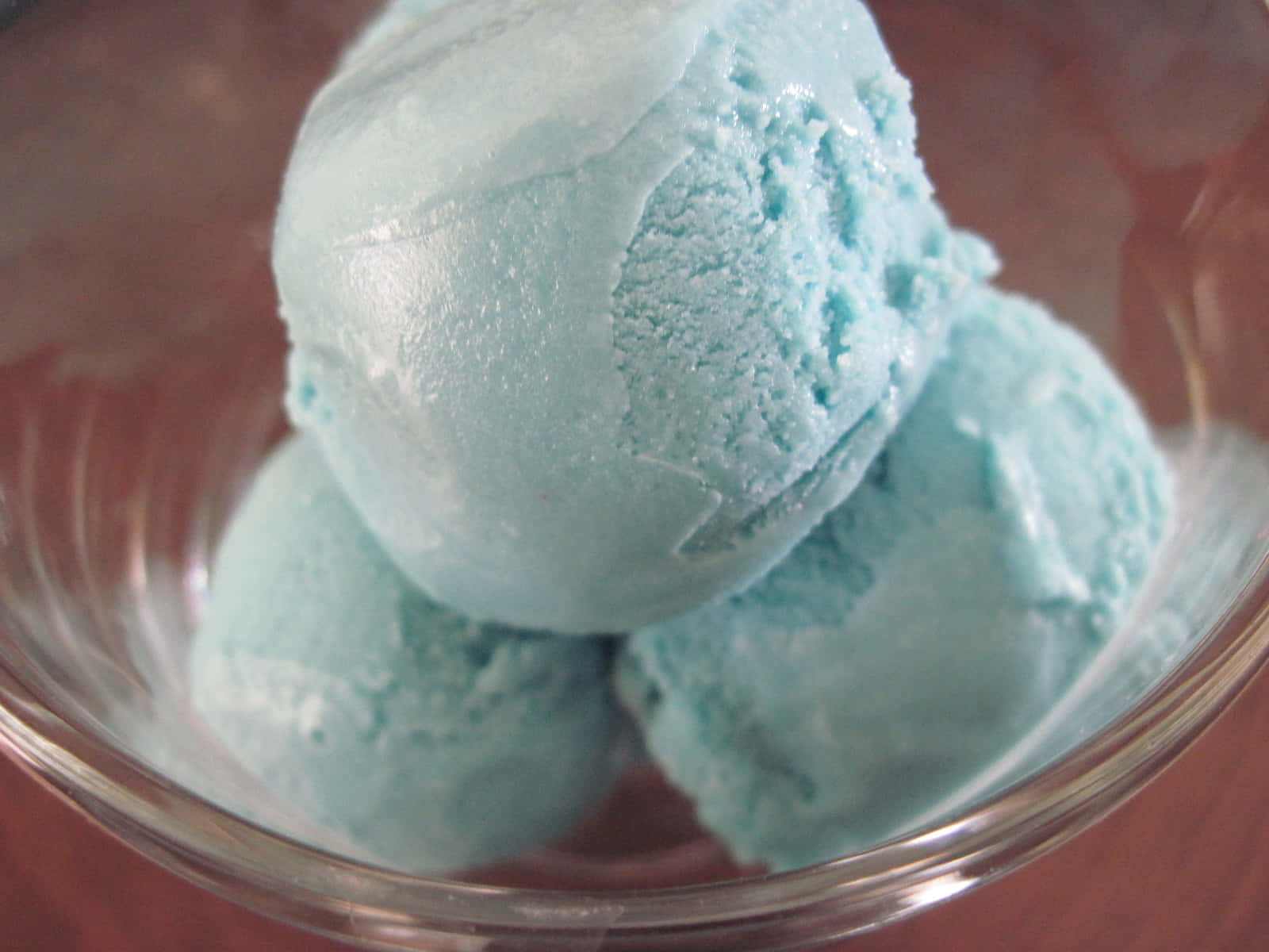 Ice Blue 桌布 壁紙 — 三球淺藍色冰淇淋放在透明玻璃碗中，背景為溫暖的木質。