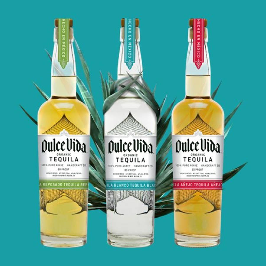cocktail 桌布 壁紙 — 三瓶 Dulce Vida 龍舌蘭酒 reposado blanco 和 añejo 站在藍綠色背景前，配有龍舌蘭葉。