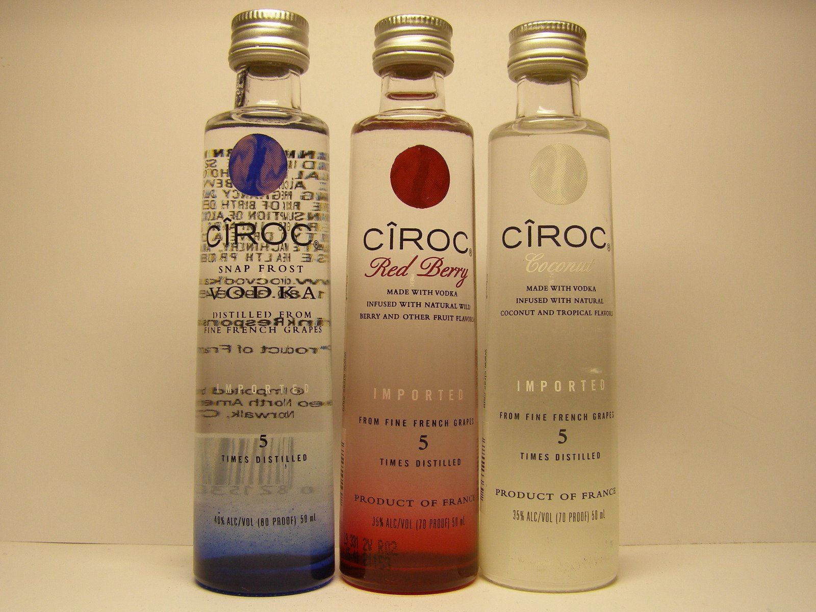 飲料 桌布 壁紙 — 三瓶 Snap Frost Red Berry 和 Coconut 口味的 Cîroc 伏特加酒並排放在純米色牆壁前。