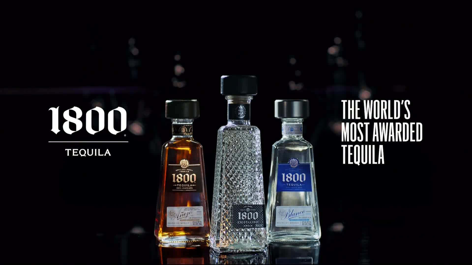 alcohol 桌布 壁紙 — 三瓶1800龍舌蘭酒在攝影棚燈光下閃耀，背景為黑暗的散景城市燈光和粗體品牌文字。