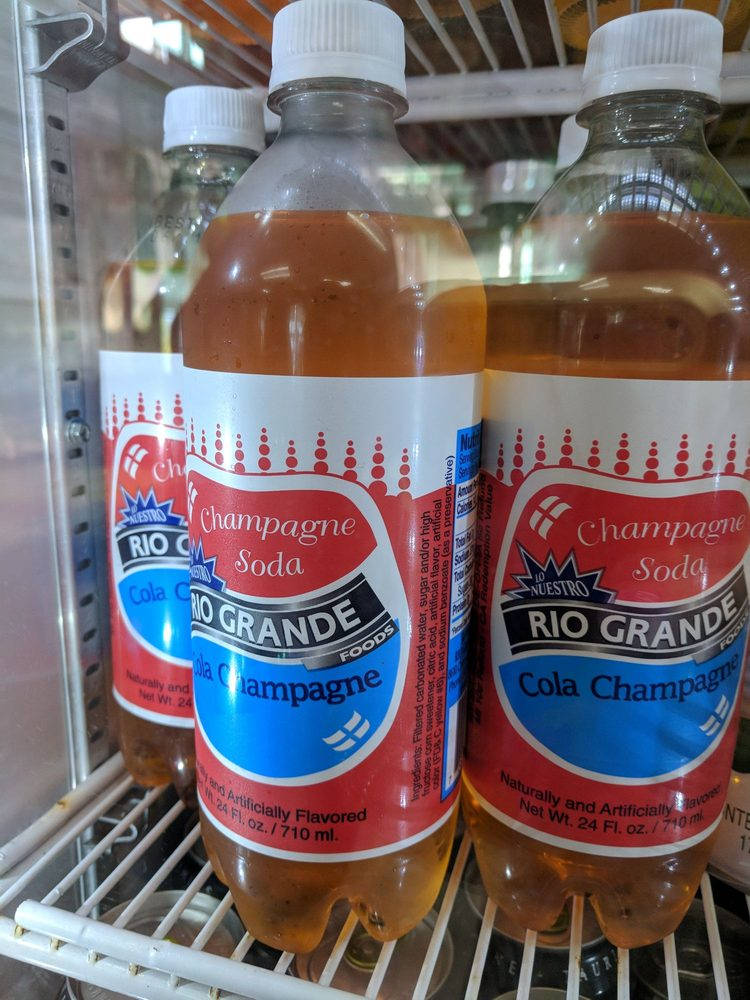 飲料 桌布 壁紙 — 三瓶Rio Grande Cola Champagne汽水冷藏放在冰箱內的鐵絲架上。