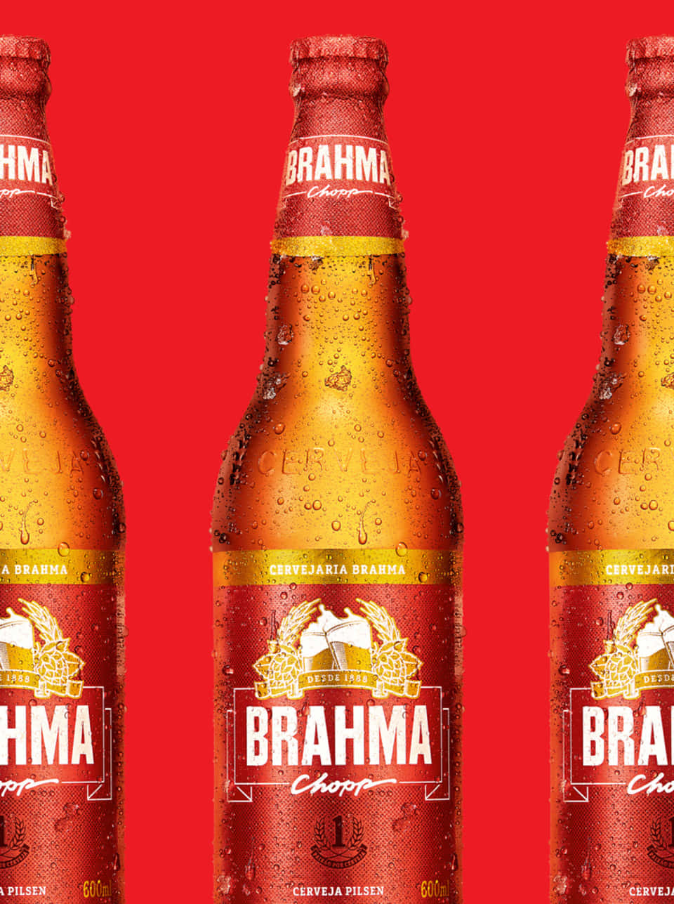 alcohol 桌布 壁紙 — 三瓶冰涼的Brahma啤酒瓶在鮮紅色背景上閃爍著冷凝水珠。