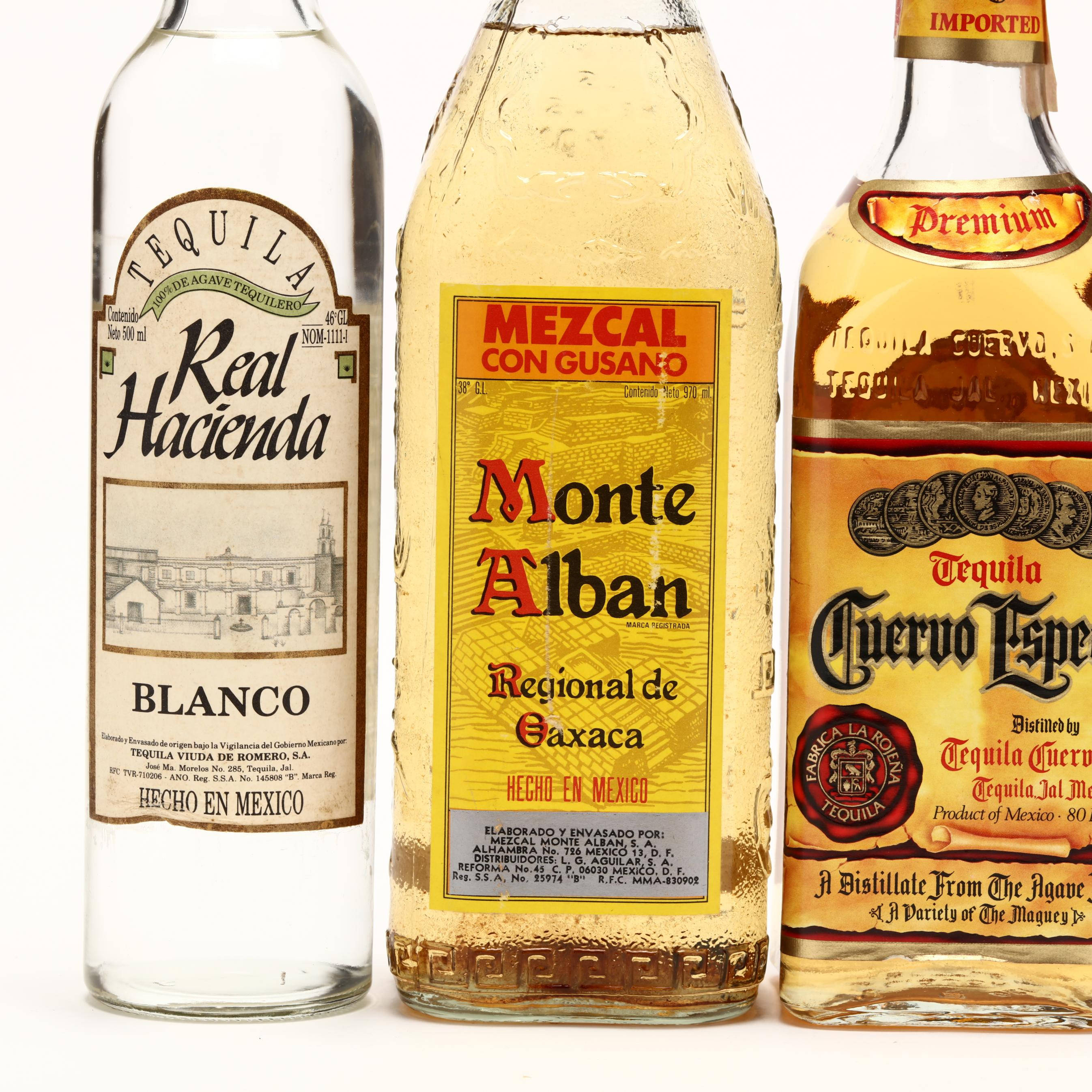 Drink 桌布 壁紙 — 三瓶冰鎮的墨西哥烈酒龍舌蘭和梅斯卡爾並排立在純白背景前。