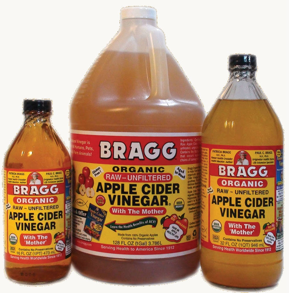 Drink 桌布 壁紙 — 三種尺寸的Bragg有機蘋果醋瓶，帶有母沉澱物，展示在純白色背景上。