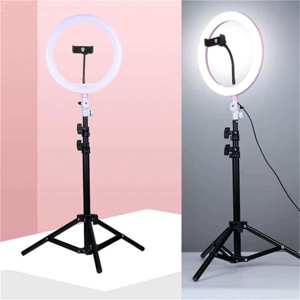 Ring Light 桌布 壁紙 — 三腳架上的環形燈，在粉紅色和灰色背景前展現柔和發光照明。