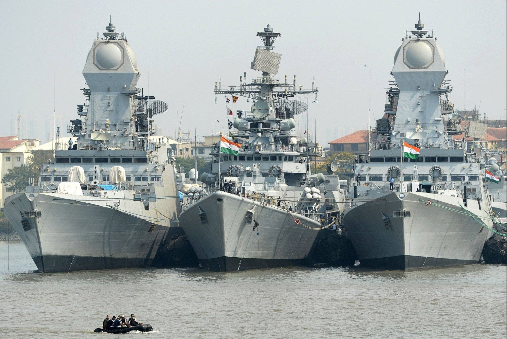 Kolkata 桌布 壁紙 — 三艘大型印度海軍軍艦並排停泊在港口，附近有一艘載有人員的小型充氣艇。