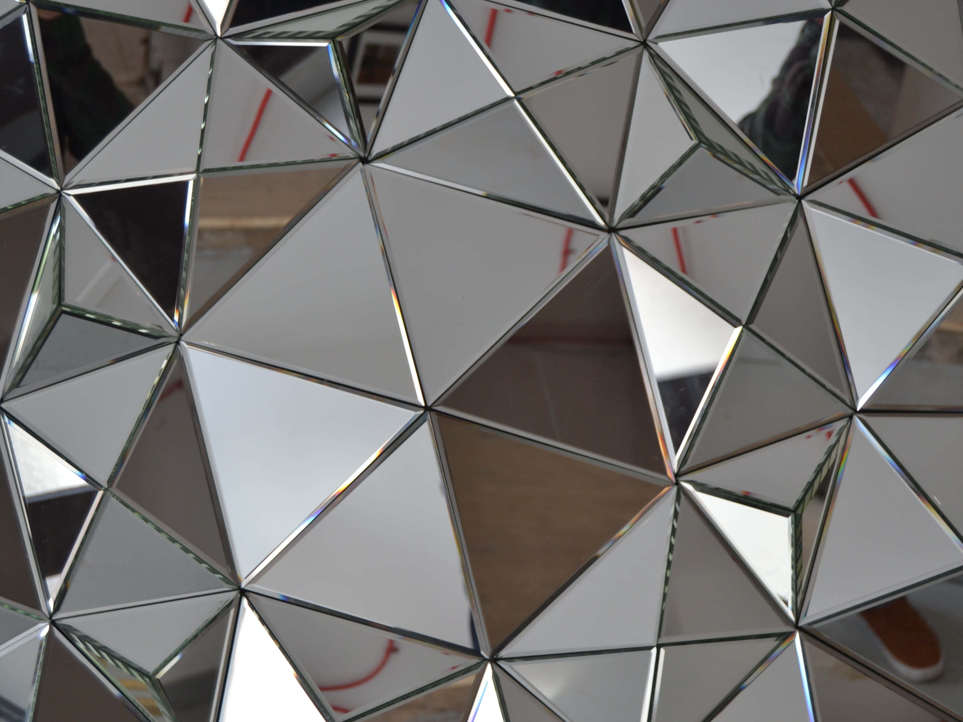 mirror 桌布 壁紙 — 三角形鏡子的幾何馬賽克特寫，反射出碎片化的環境，帶有金屬銀色框架。