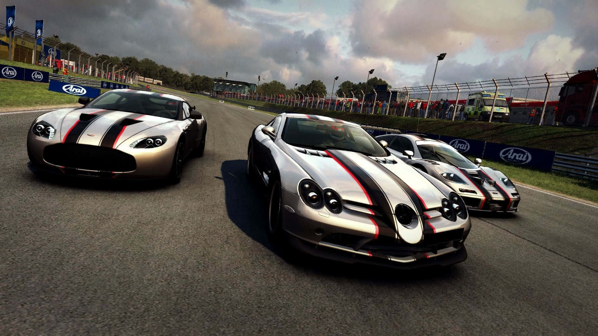 1080p Grid Autosport 桌布 壁紙 — 三輛帶有黑色和紅色條紋的銀色跑車在潮濕的瀝青賽道上緊密比賽，天空多雲。
