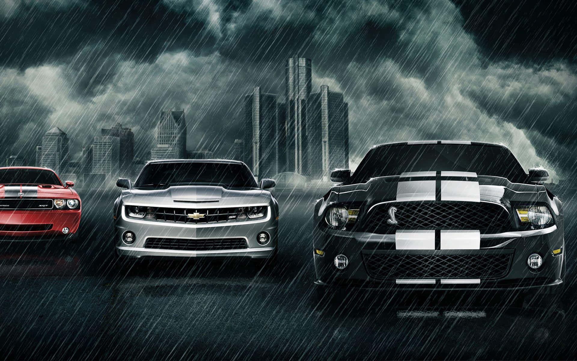 Muscle Cars 桌布 壁紙 — 三輛強勁的肌肉車在暴雨中面向前方，背景是暴風雨的城市天際線和高聳的摩天大樓。