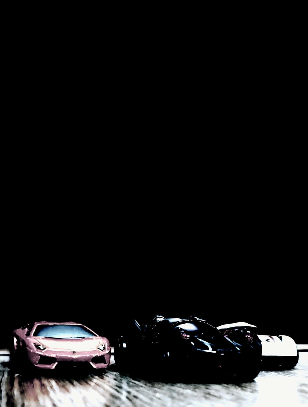 Sport Cars from a side 壁紙 — 三輛時尚跑車的剪影，在純黑背景上以戲劇性燈光突顯其空氣動力學形態。