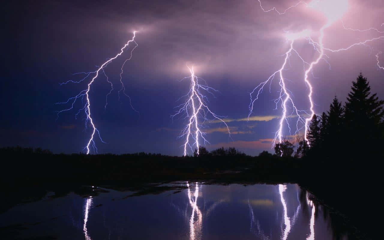 thunder 桌布 壁紙 — 三道巨大的閃電照亮了平靜湖泊上方暴風雨的夜空，湖面反射出它們的電光。