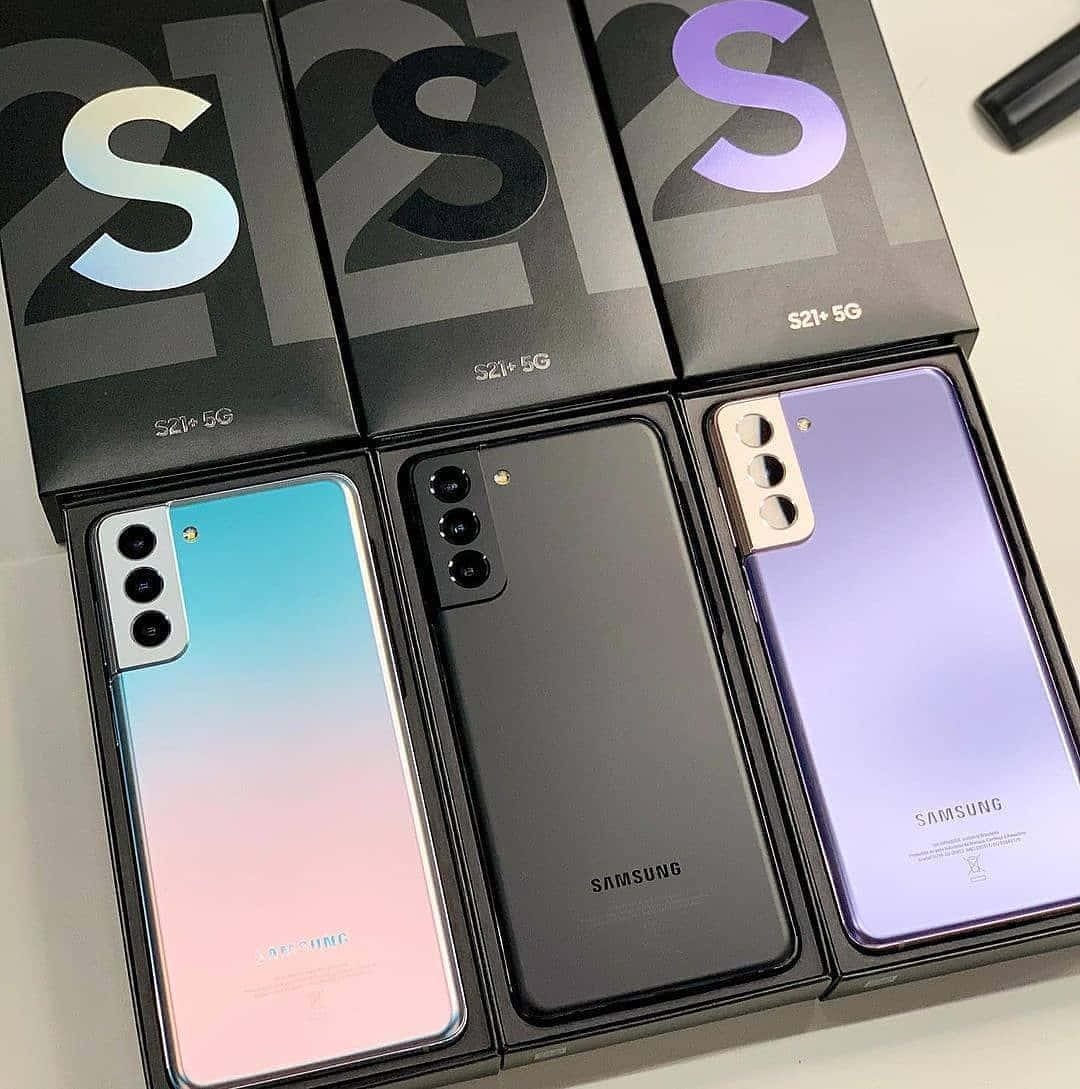 Note 10 桌布 壁紙 — 三部 Samsung S21+ 5G 手機，呈現漸變藍、粉紅、霧面黑和紫色調，連同包裝盒展示在潔白表面上。