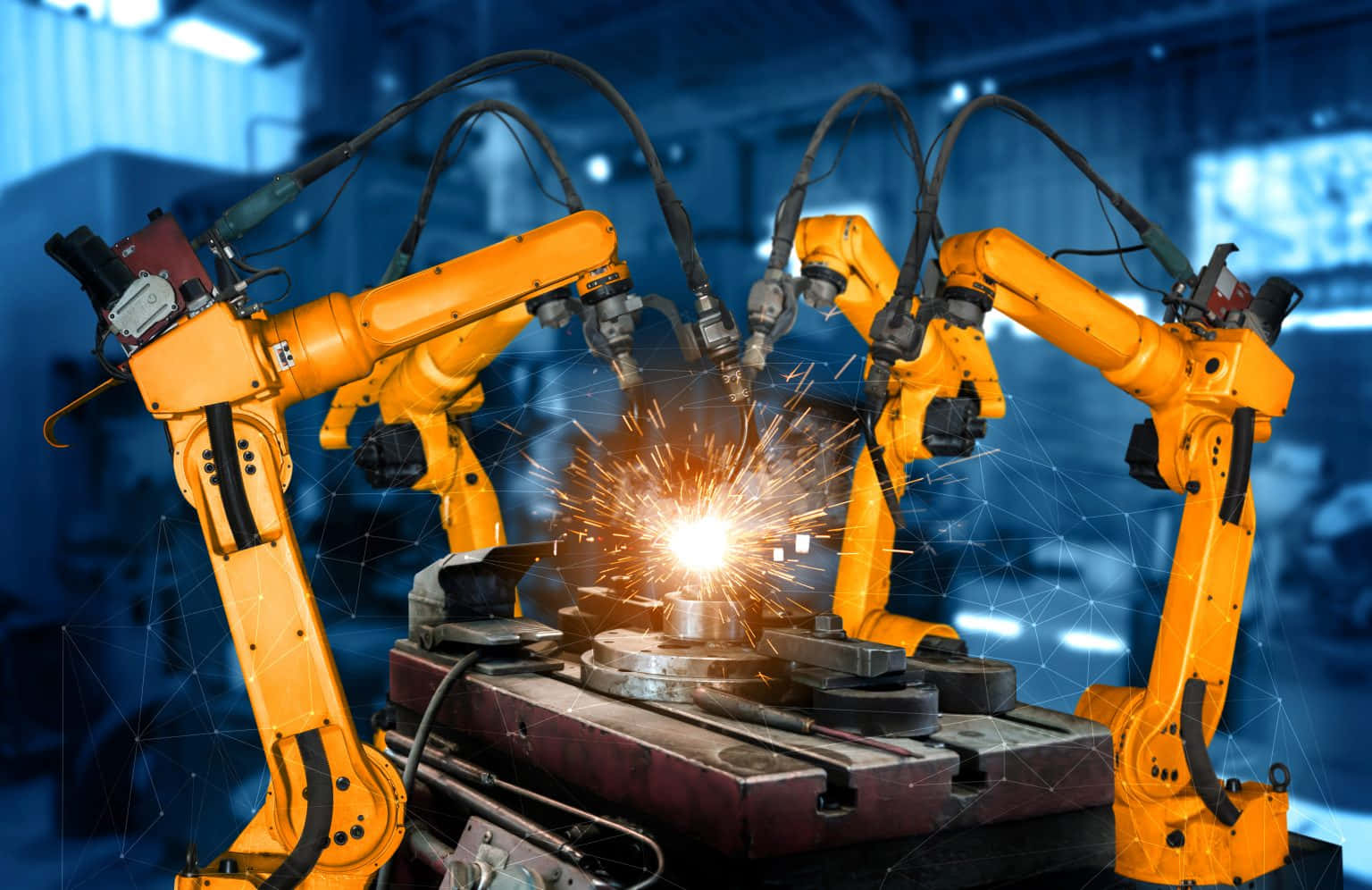 Manufacturing 桌布 壁紙 — 三隻亮黃色的機械手臂在藍色調的工業工廠中焊接金屬，火花四濺。