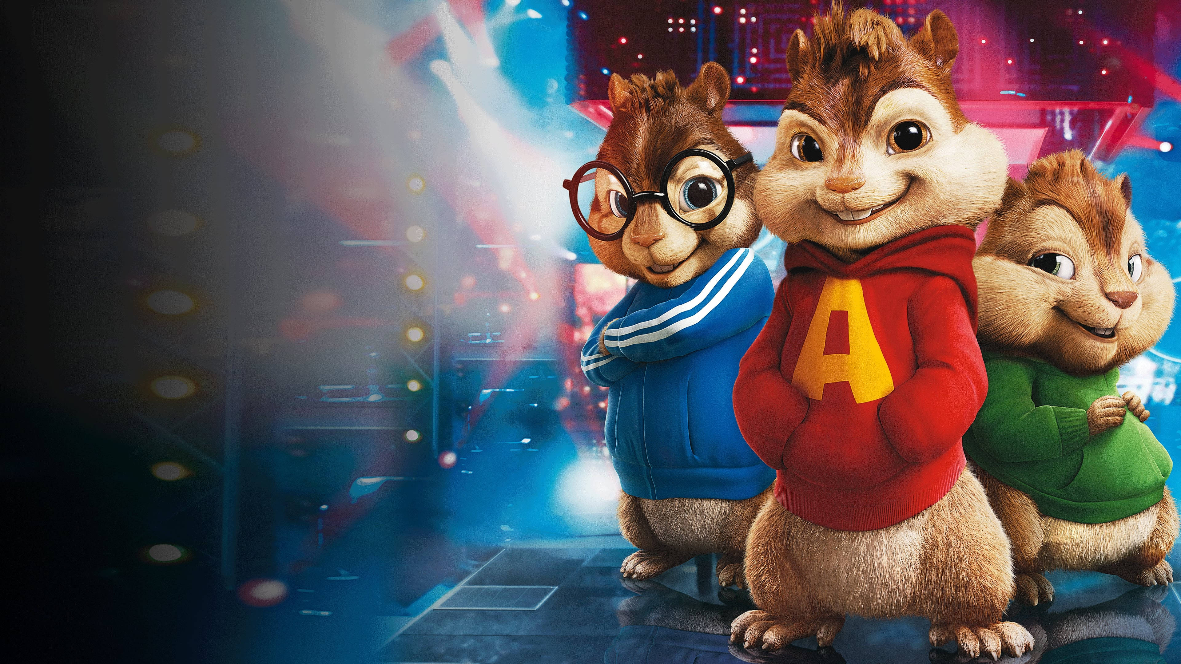 Chipmunks 桌布 壁紙 — 三隻動畫花栗鼠穿著色彩繽紛的連帽衫，在耀眼的燈光下自信地擺姿勢於充滿活力的舞台上。