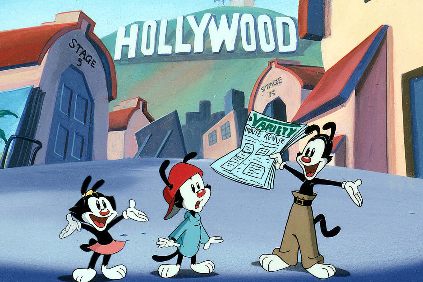 Animaniacs 桌布 壁紙 — 三隻卡通貓在好萊塢片場開心地與《Variety》報紙擺姿勢，背景是明亮的天空。