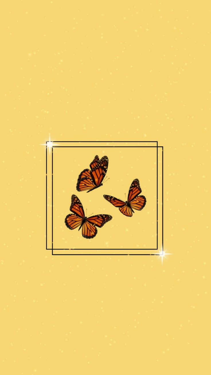 Butterflies 桌布 壁紙 — 三隻帝王斑蝶在柔和的黃色斑點背景上，於一個發光的正方形框架內翩翩飛舞。