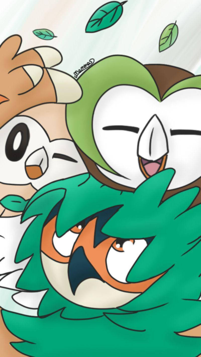Rowlet 桌布 壁紙 — 三隻快樂的卡通貓頭鷹寶可夢，帶有綠色葉子點綴和俏皮的表情。