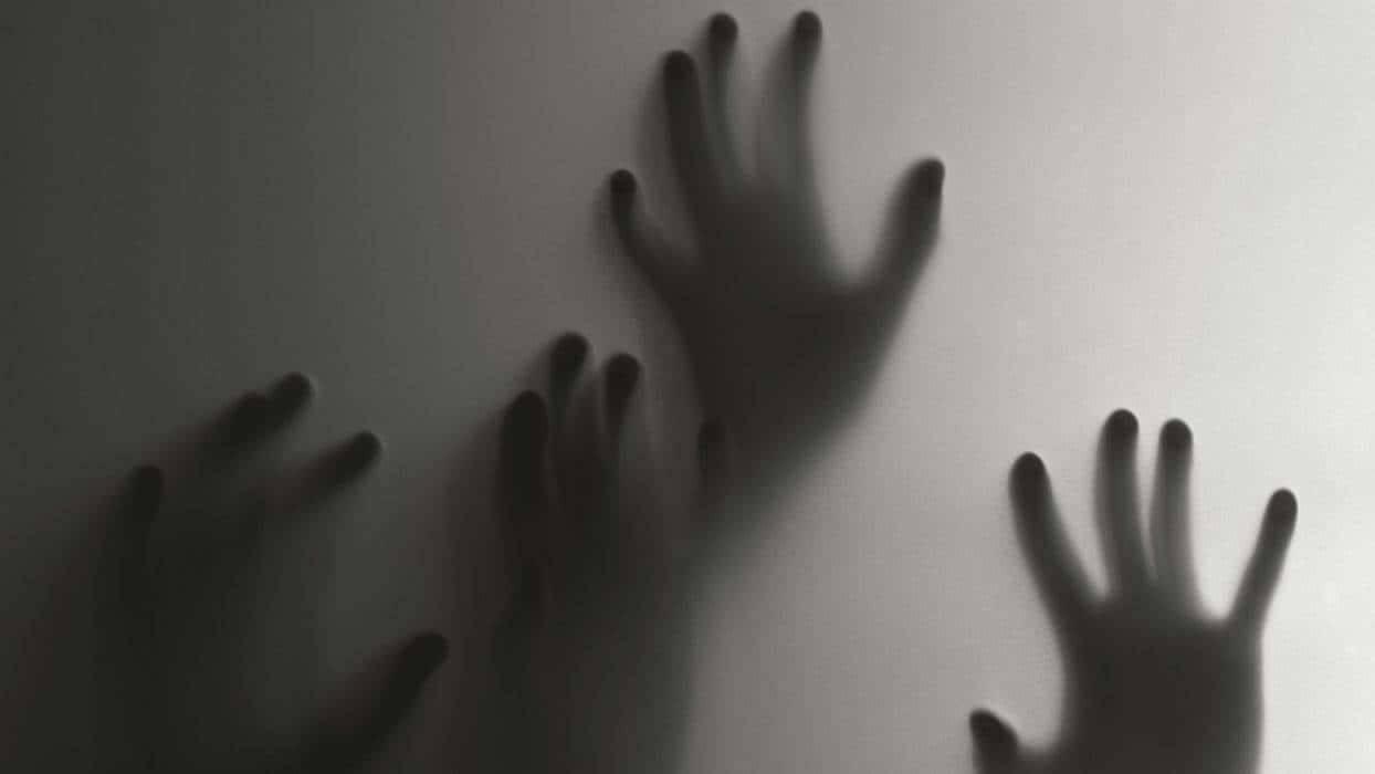 Scared 桌布 壁紙 — 三隻模糊的手按在磨砂玻璃表面上，投射出單色的詭異陰影。