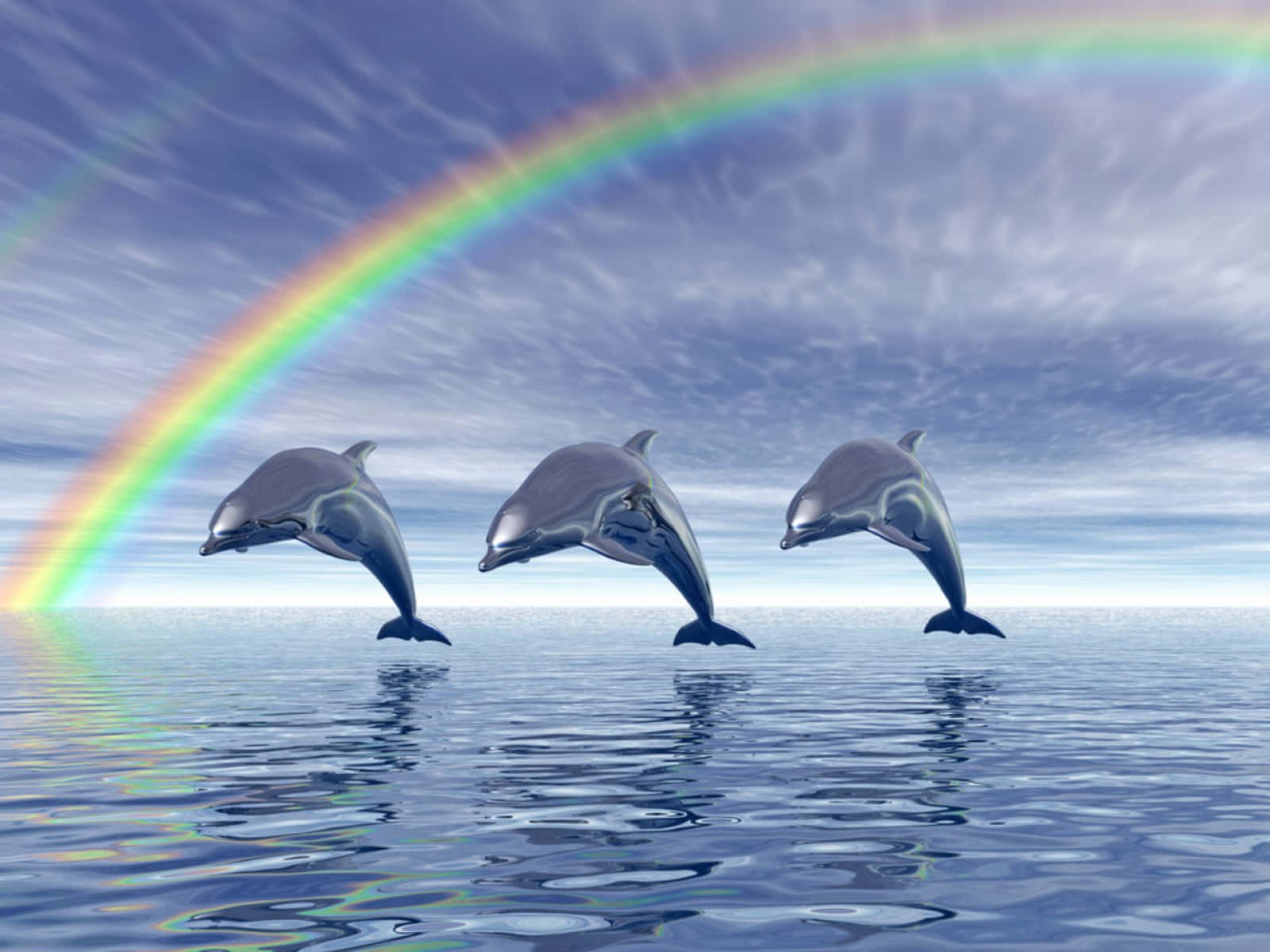 動物 桌布 壁紙 — 三隻海豚在平靜的海水中優雅地躍起，在一道橫跨多雲天空的鮮豔彩虹之下。