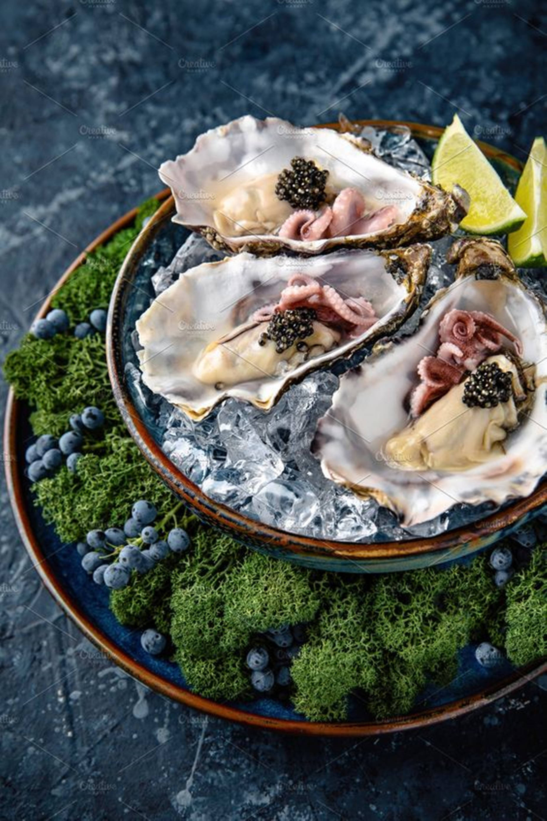 food iPhone 桌布 壁紙 — 三隻生蠔放在冰上，配上魚子醬和章魚觸鬚，飾以萊姆角和藍莓，放在苔蘚盤上。