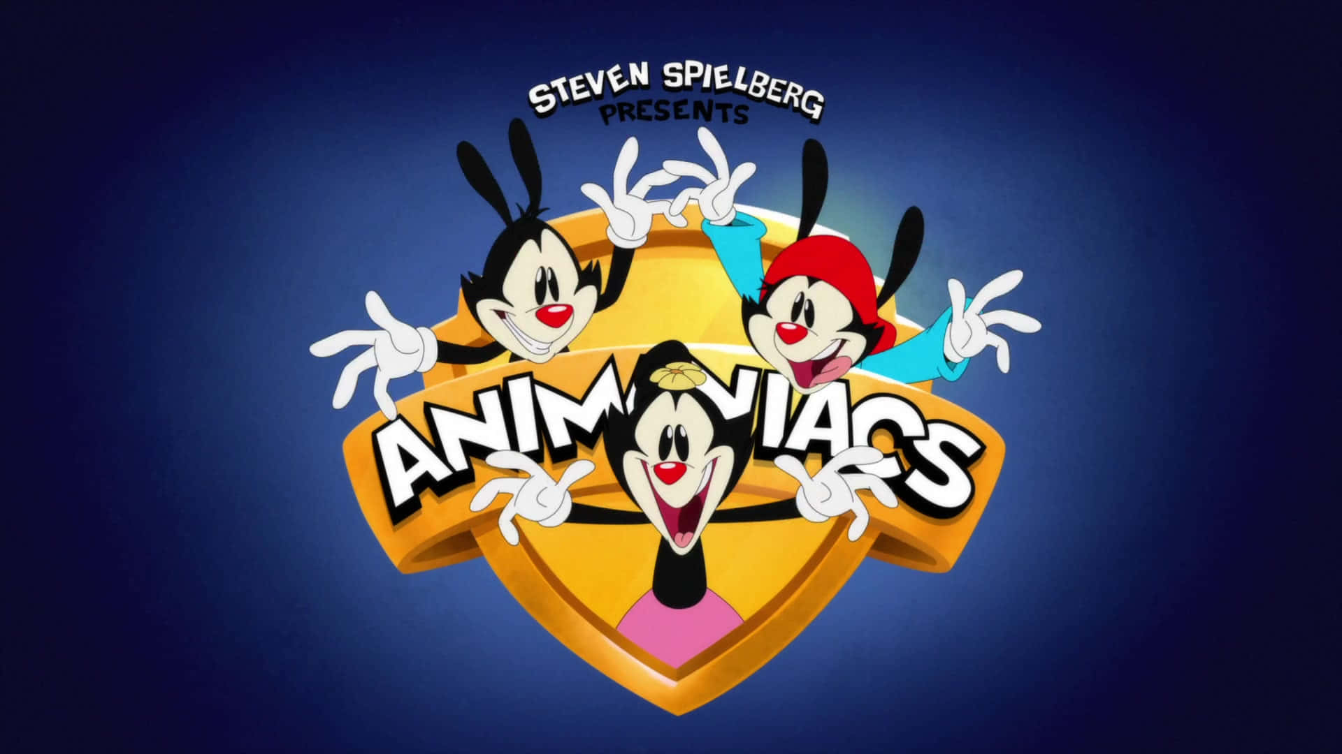Animaniacs 桌布 壁紙 — 三隻穿著紅色、藍色和粉紅色服裝的卡通兔子，在深藍色漸變背景前，圍著一個金色盾牌標誌愉快地擺姿勢。