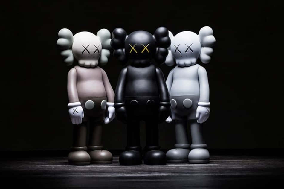 桌布 壁紙 — 三隻米色、黑色和白色的KAWS Companion公仔排成一排，站在深色背景前，燈光效果戲劇化。