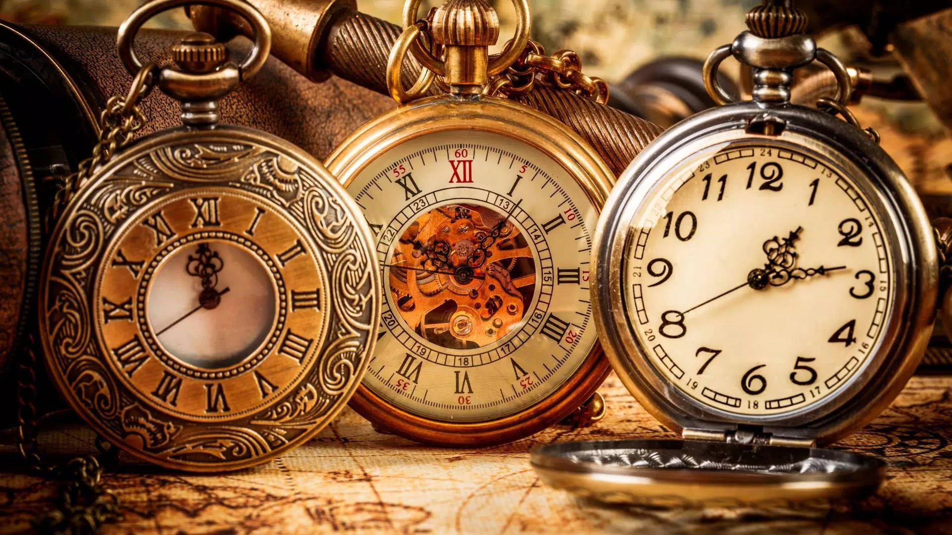 Clock 桌布 壁紙 — 三隻裝飾華麗的復古懷錶，帶有精緻的金色細節和裸露的齒輪，放在一張古老的地圖上。