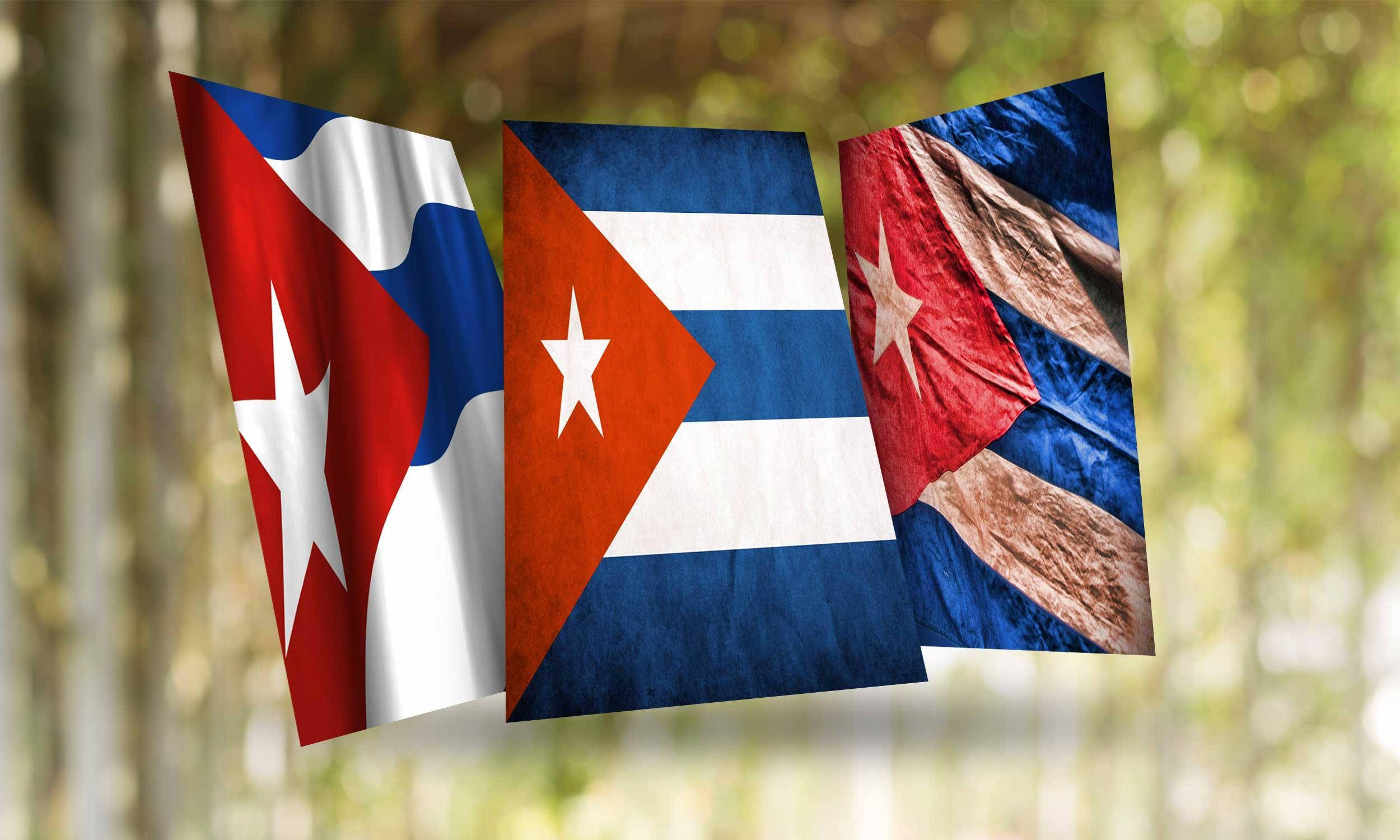 Cuban 桌布 壁紙 — 三面古巴國旗在陽光明媚的森林中飄揚，背景為模糊的綠色散景。
