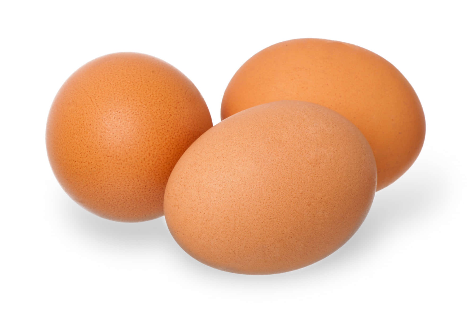 Eggs 桌布 壁紙 — 三顆光滑的棕色雞蛋在潔白背景上排列成三角形，帶有柔和陰影。