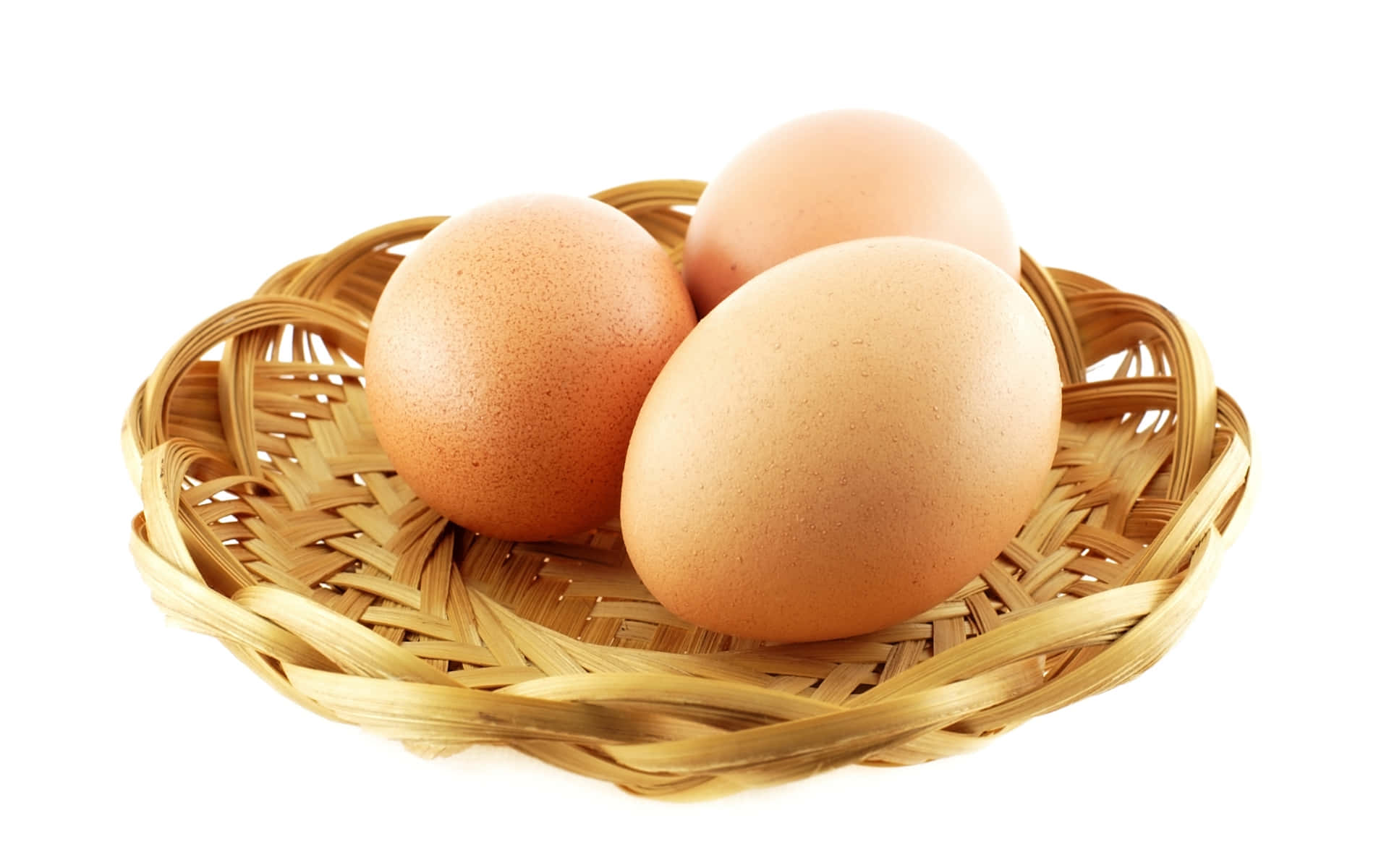 Eggs 桌布 壁紙 — 三顆光滑的棕色雞蛋放在一個編織竹籃裡，背景是潔淨的白色。