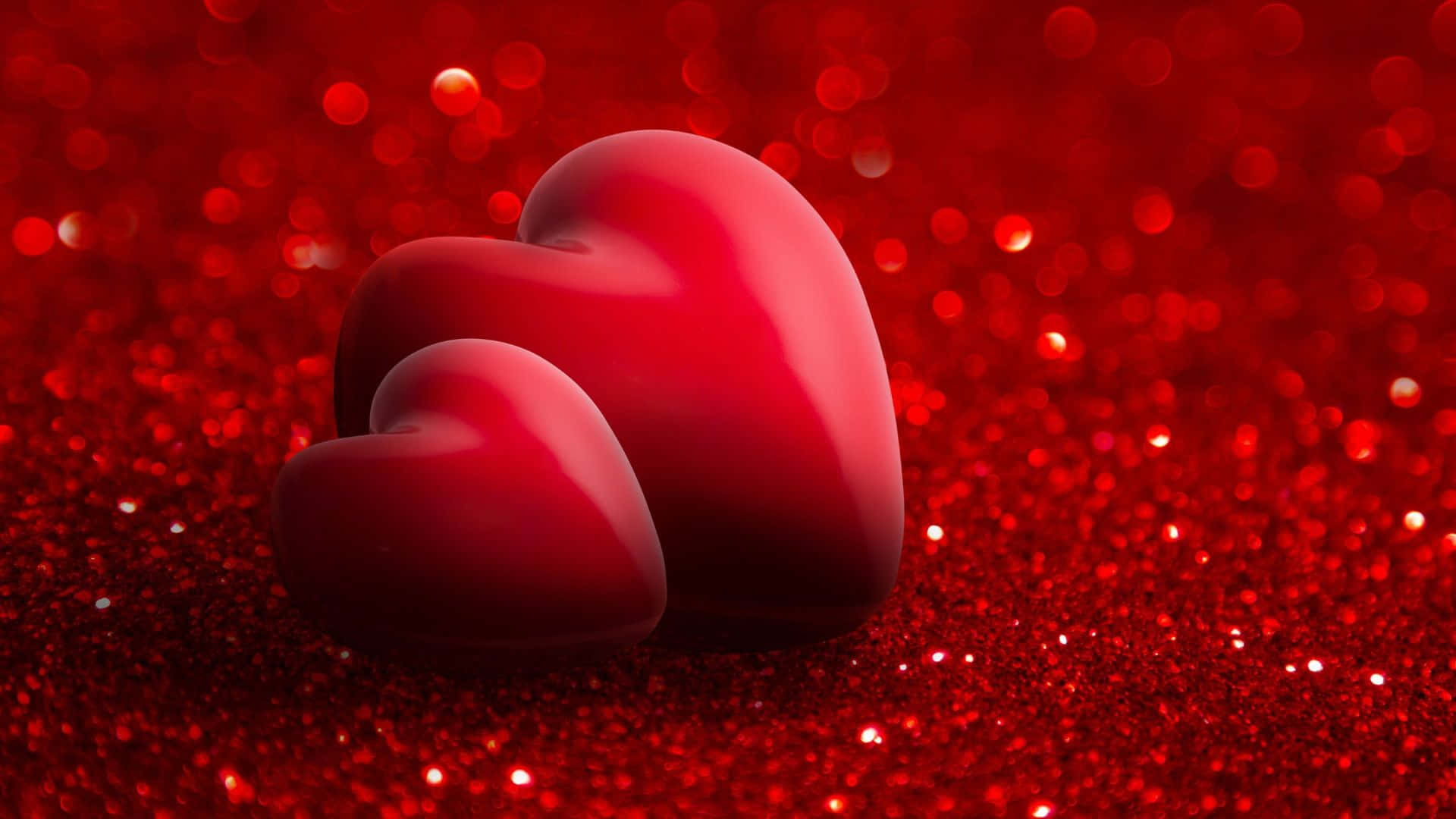 Red Hearts 桌布 壁紙 — 三顆光澤的紅色心形放在閃閃發光的紅色亮粉表面上，背景有柔和散景燈光。