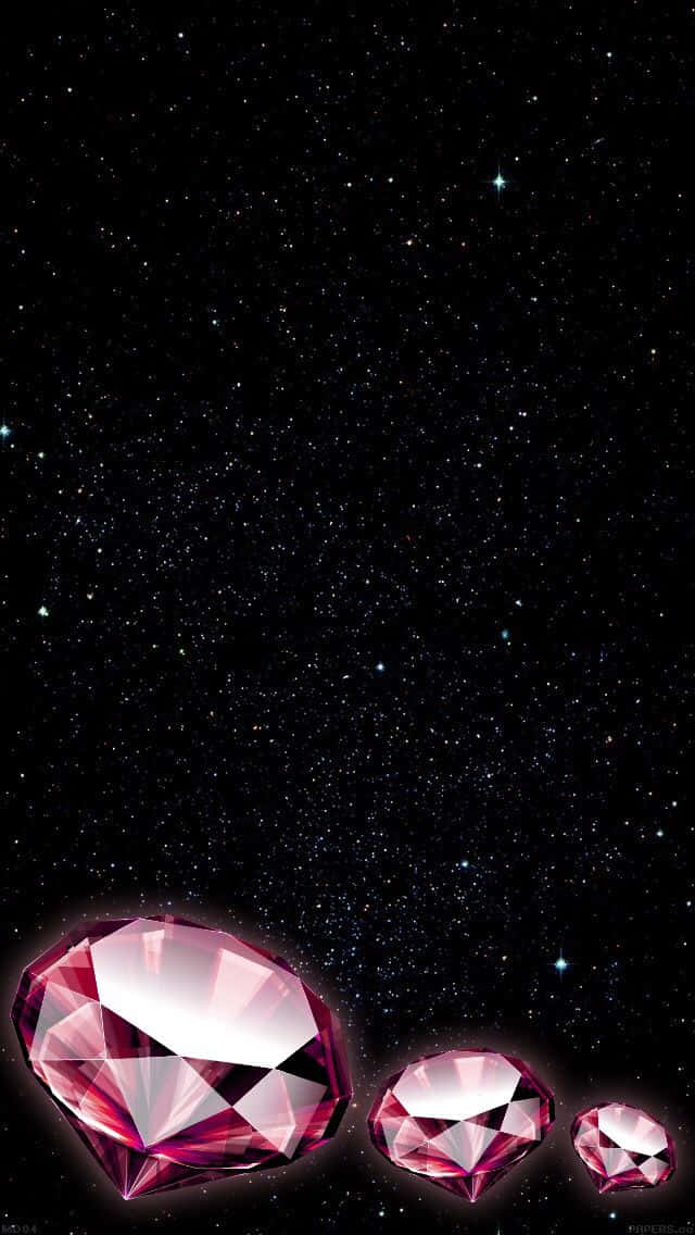 Pink Diamond 桌布 壁紙 — 三顆發光的粉紅色鑽石在繁星閃爍的夜空下漂浮。
