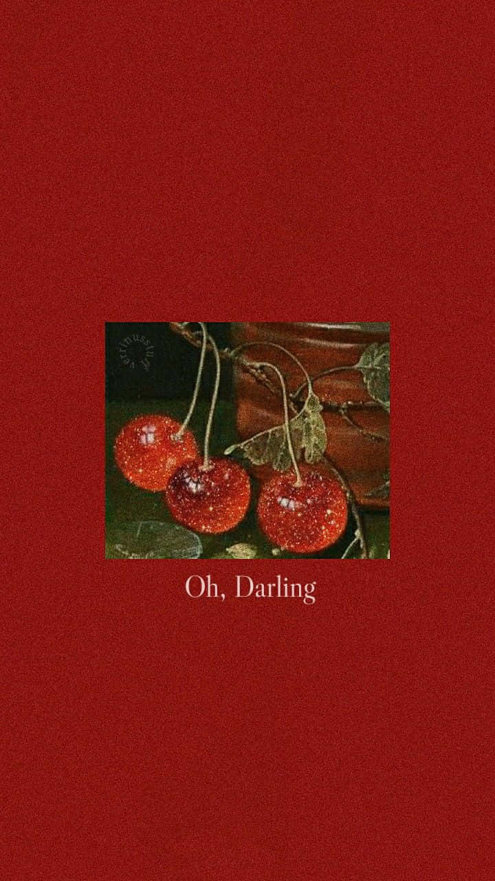 Soft Red Aesthetic 桌布 壁紙 — 三顆閃亮的紅櫻桃帶梗，放在深色表面上，背景為帶紋理的深紅色，並有文字 Oh Darling。