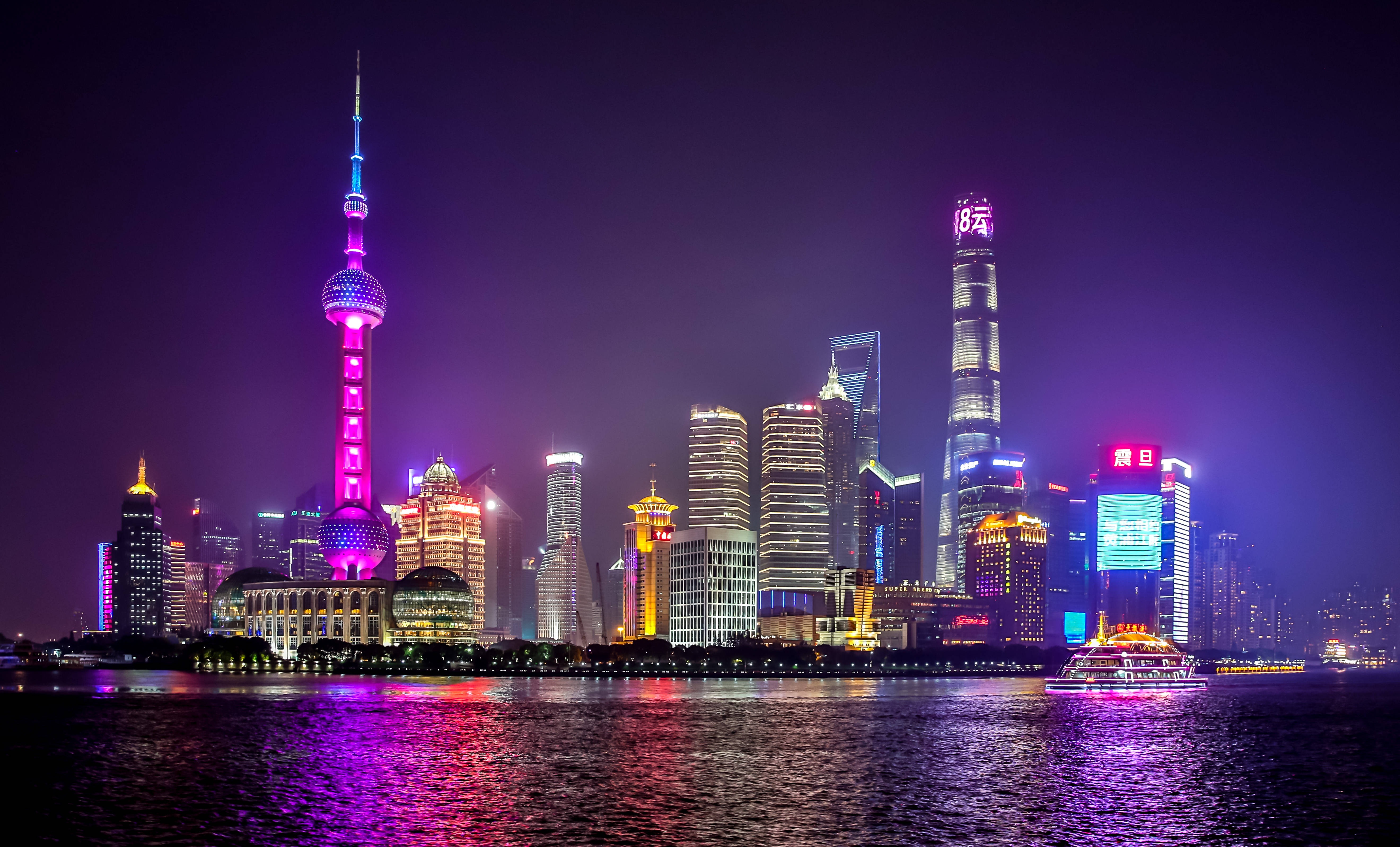 霓虹城市動態圖 桌布 壁紙 — 上海令人目眩的夜景，霓虹燈閃爍的摩天大樓和發光的塔樓倒映在黑暗的河流中。