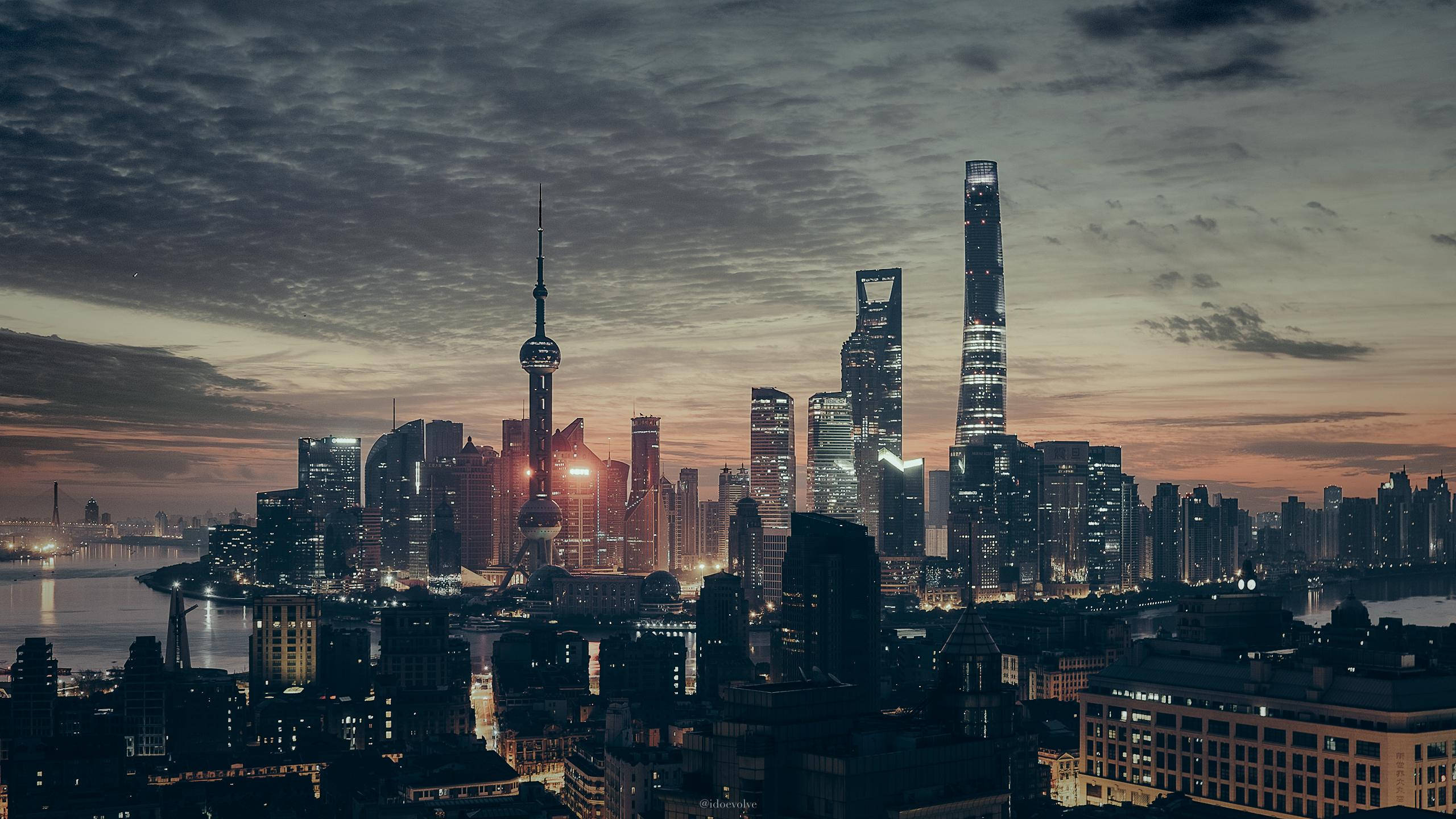 blade 桌布 壁紙 — 上海夜景全景，黃昏時分燈火璀璨的天際線，雲彩在漸變色的天空中延伸。