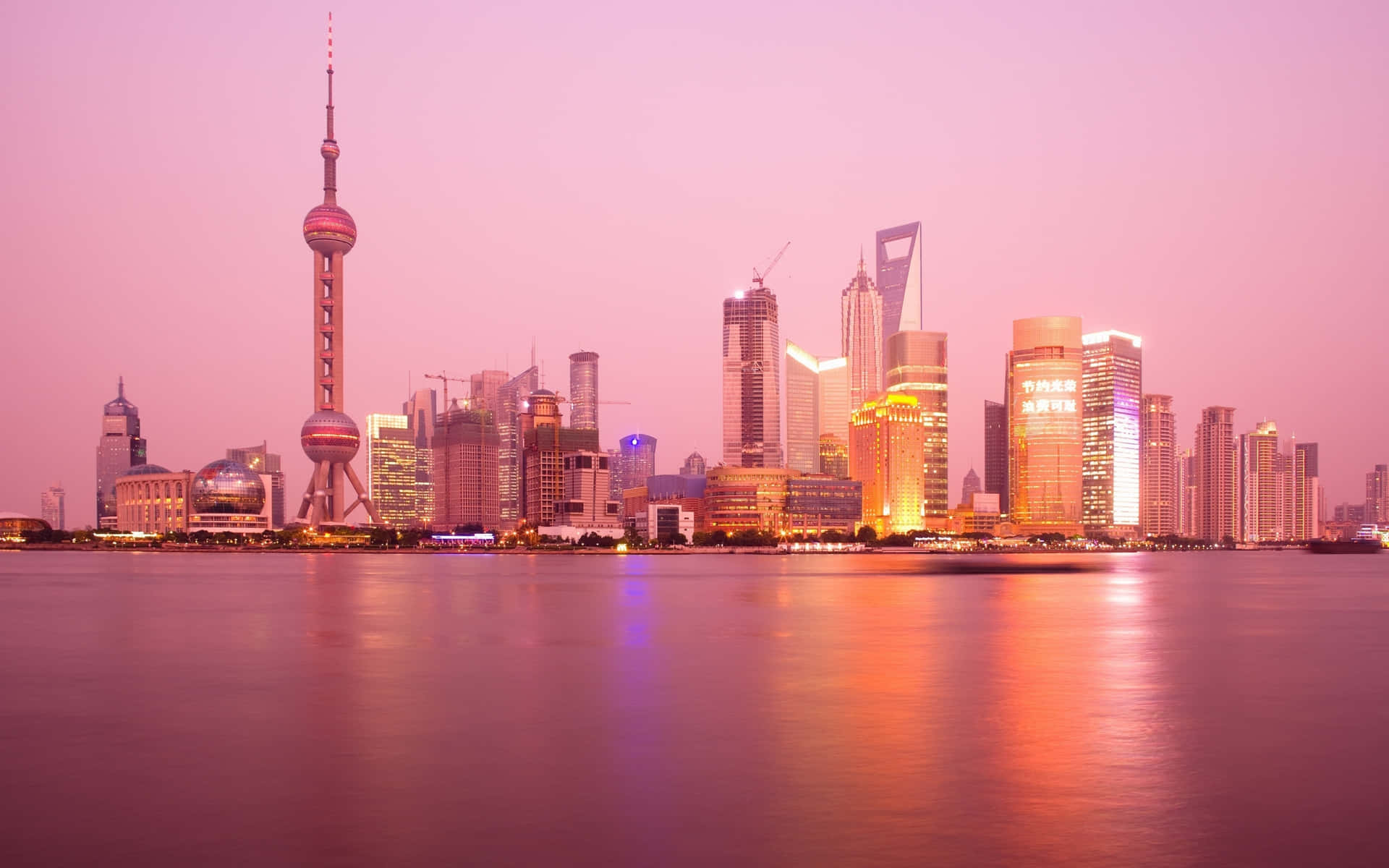 Pink City 桌布 壁紙 — 上海天際線的壯麗日落景色，東方明珠塔和燈火通明的摩天大樓倒映在平靜的水面上。
