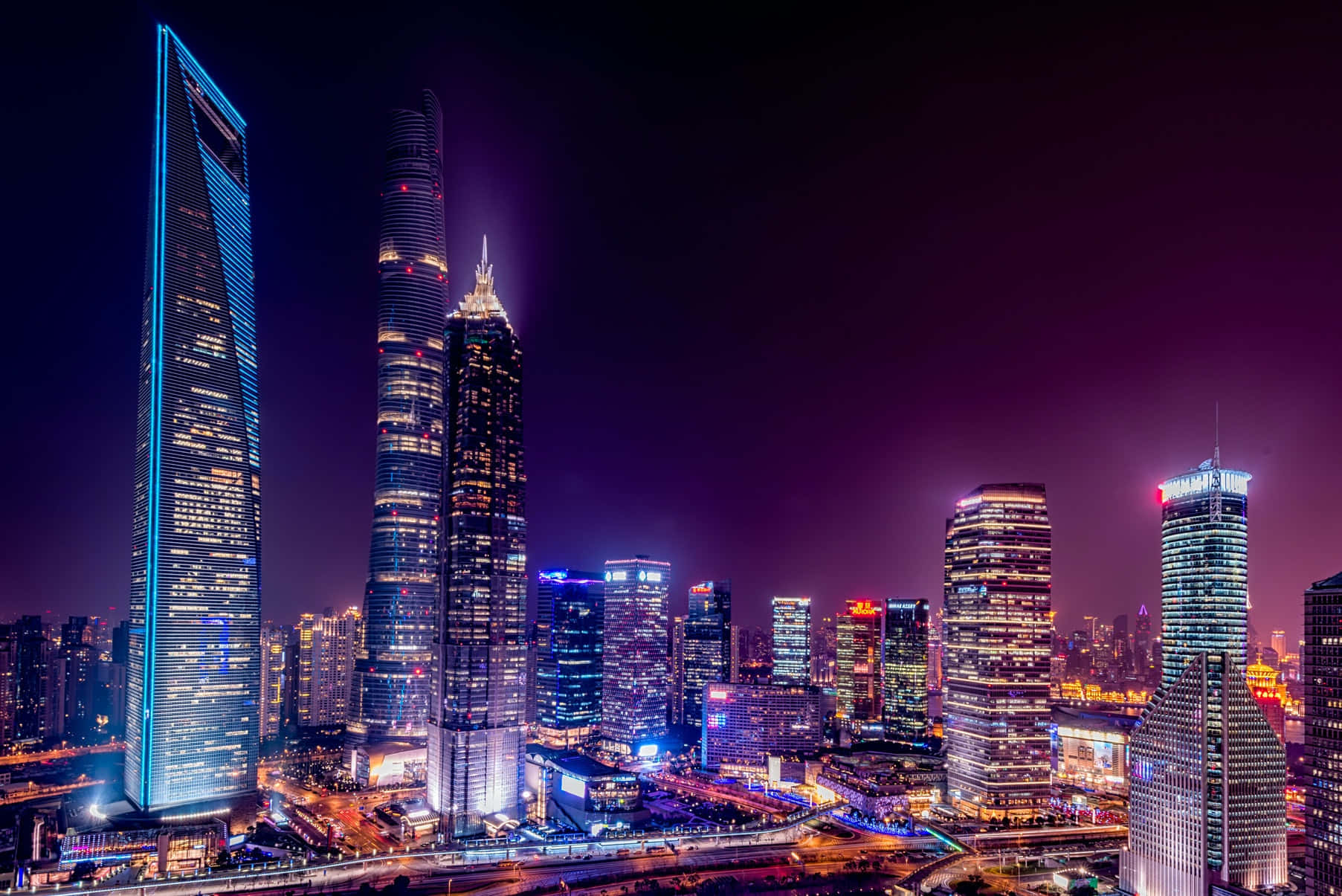 城市風景 桌布 壁紙 — 上海天際線的璀璨夜景，摩天大樓在深紫色天空中閃耀。
