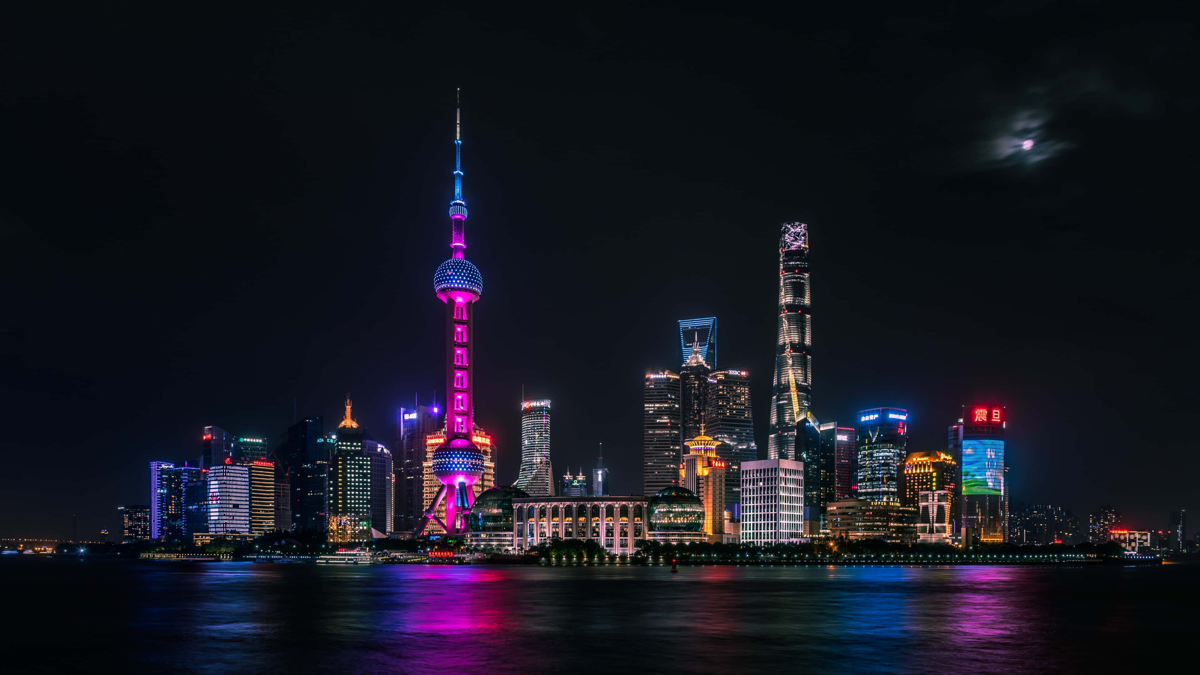 桌布 壁紙 — 上海天際線的耀眼夜景，東方明珠塔閃爍著粉紅色和藍色光芒，在月光下的黑暗水面上倒映。