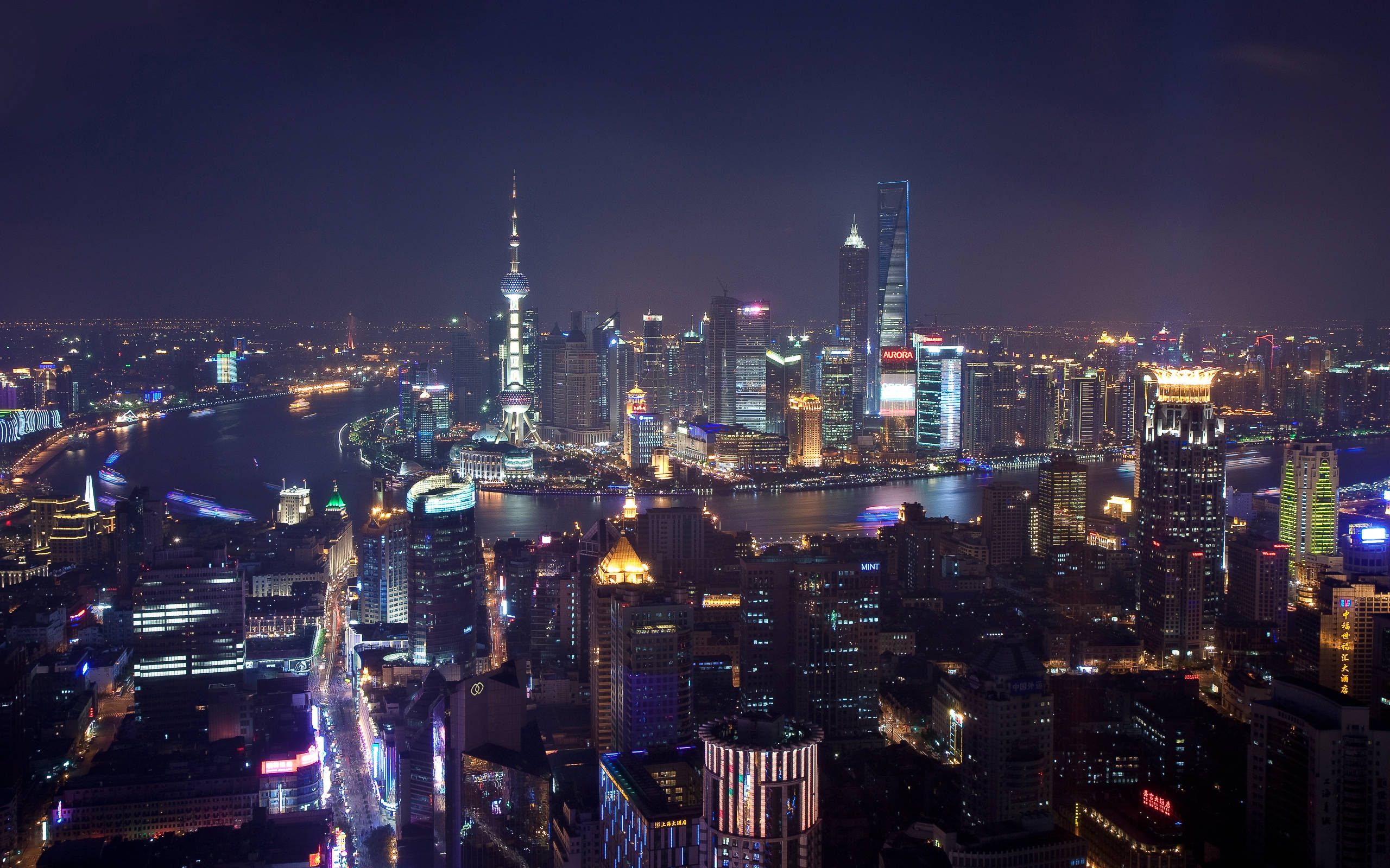 Shanghai 桌布 壁紙 — 上海天際線的迷人夜間鳥瞰圖，黃浦江在閃爍的高樓大廈之間閃耀。