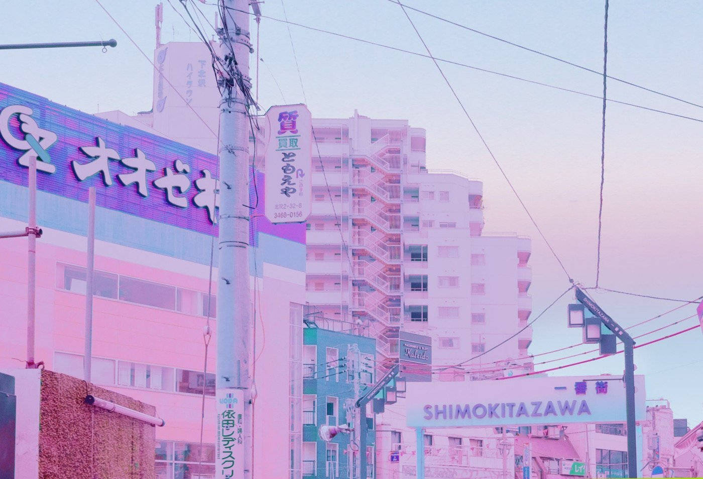 pastel 桌布 壁紙 — 下北澤的粉彩粉紅和紫色濾鏡城市街景，建築物、招牌和架空電線在柔和暮色天空下。