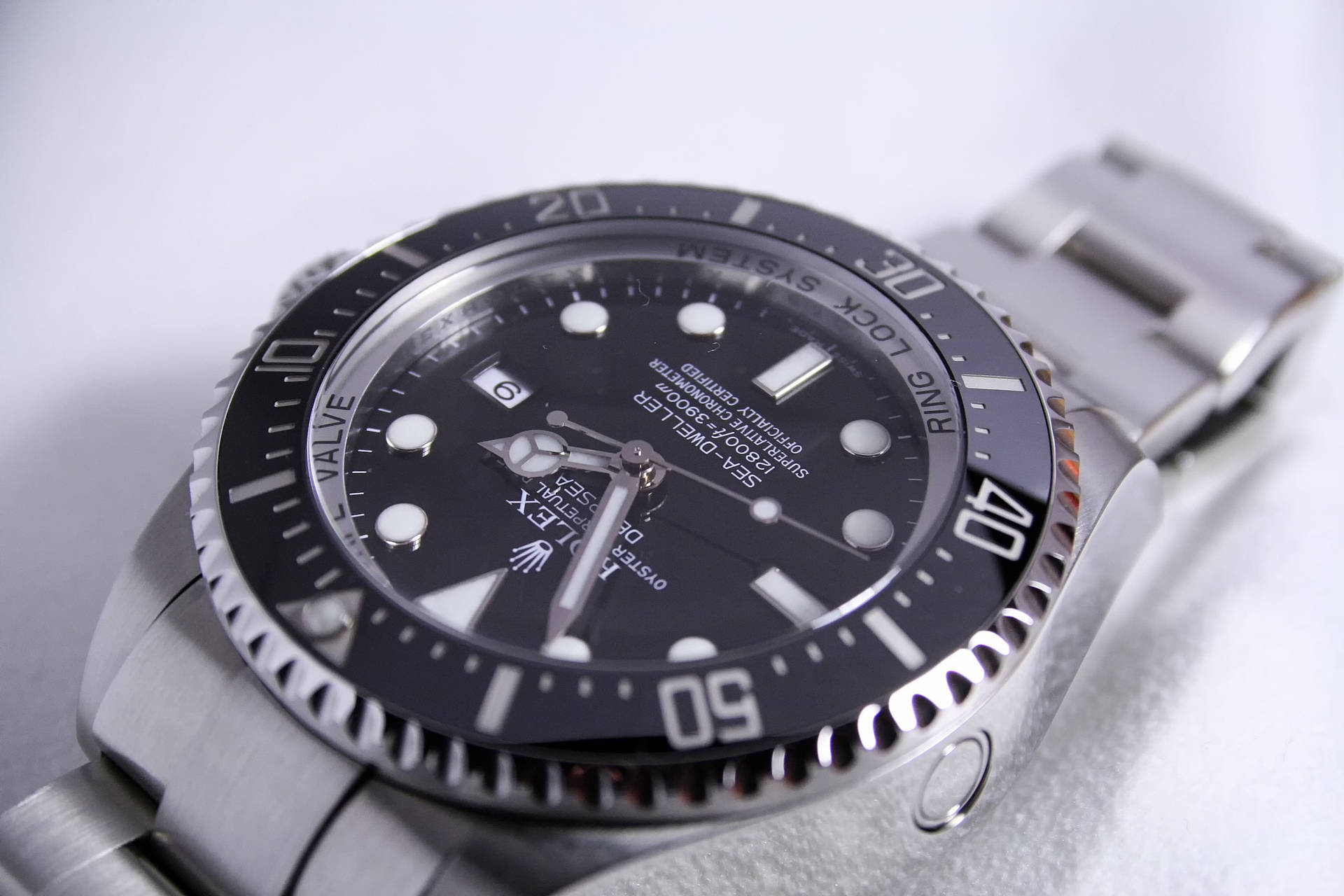 Silver 桌布 壁紙 — 不鏽鋼勞力士Submariner手錶的特寫，黑色錶盤和陶瓷錶圈，白色背景。