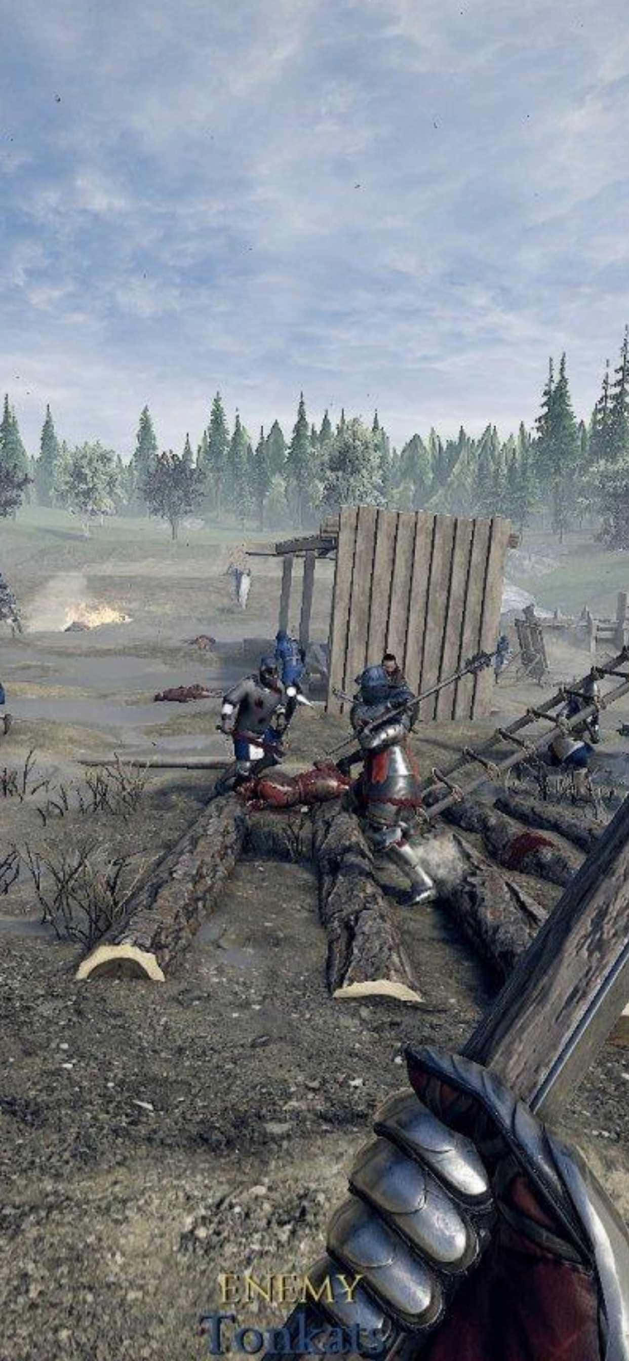 iPhone Xs Max Mordhau 桌布 壁紙 — 中世紀戰士在泥濘的戰場上，在陰天之下，與木製路障和倒下的敵人交戰。