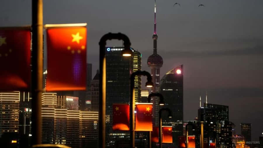Buildings 桌布 壁紙 — 中國國旗在黃昏時分溫暖地照亮上海璀璨的天際線，標誌性的東方明珠塔高高聳立。