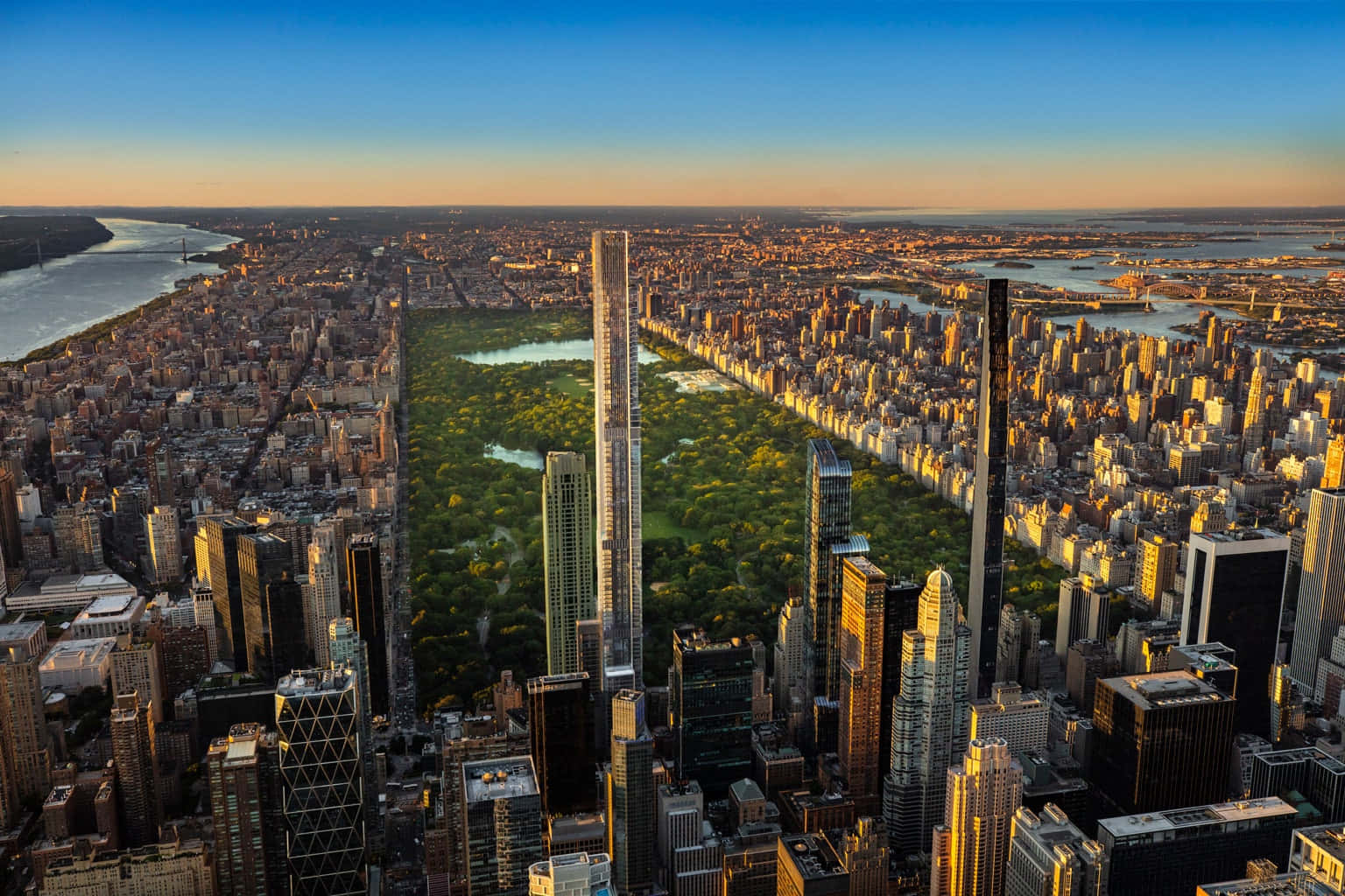 Nyc 桌布 壁紙 — 中央公園的鳥瞰圖，將曼哈頓摩天大樓一分為二，金色時刻中可見河流和遠處的橋樑。