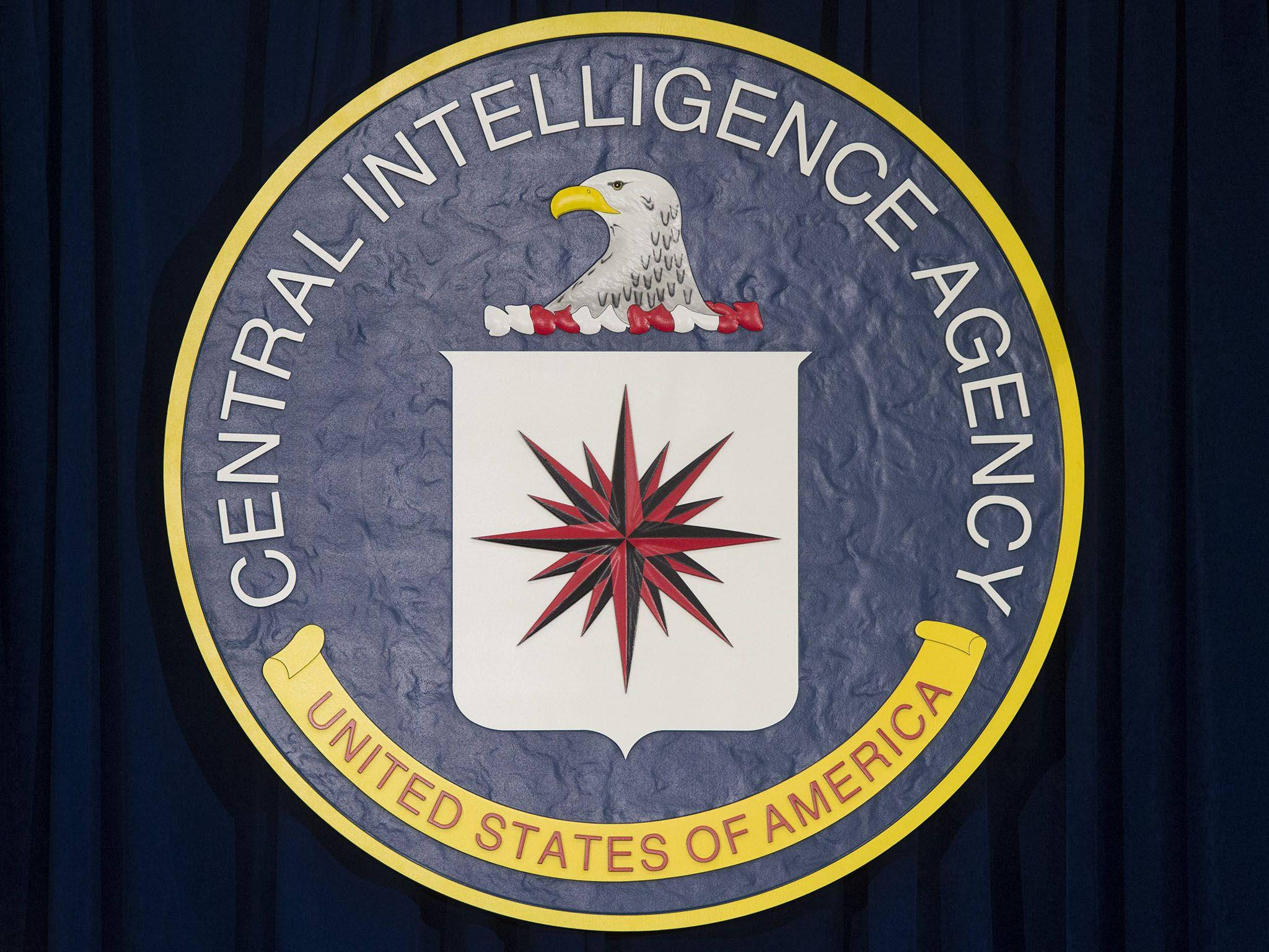 Cia 桌布 壁紙 — 中央情報局的官方印章顯示在帶有紋理背景的深藍色窗簾上。
